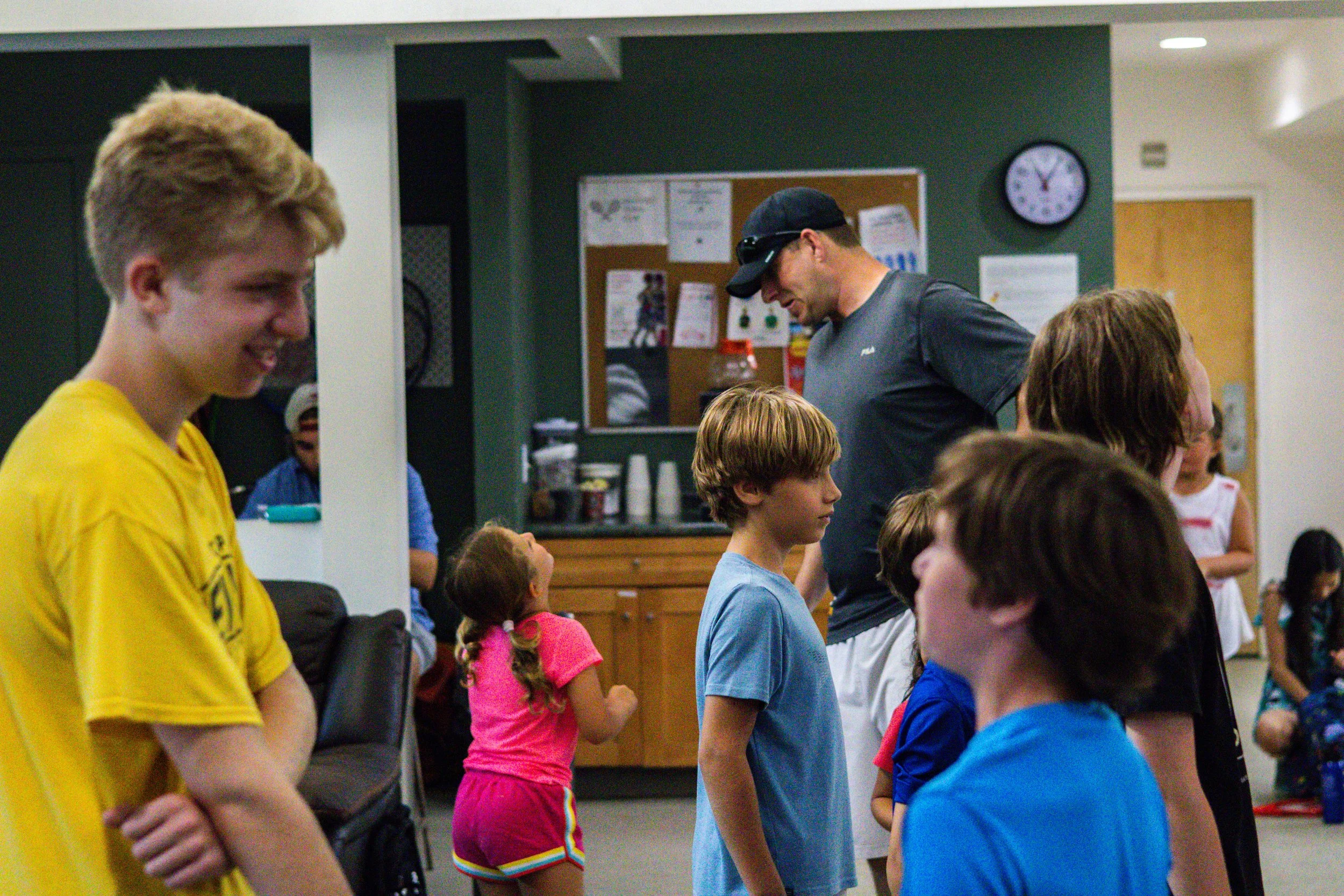Group of junior players waiting in line during Westport Tennis Club’s indoor summer program activities.