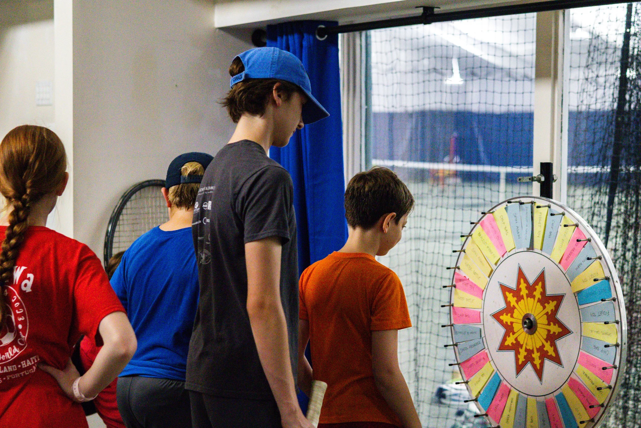 Children participating in a prize wheel activity during Westport Tennis Club summer tennis camp.