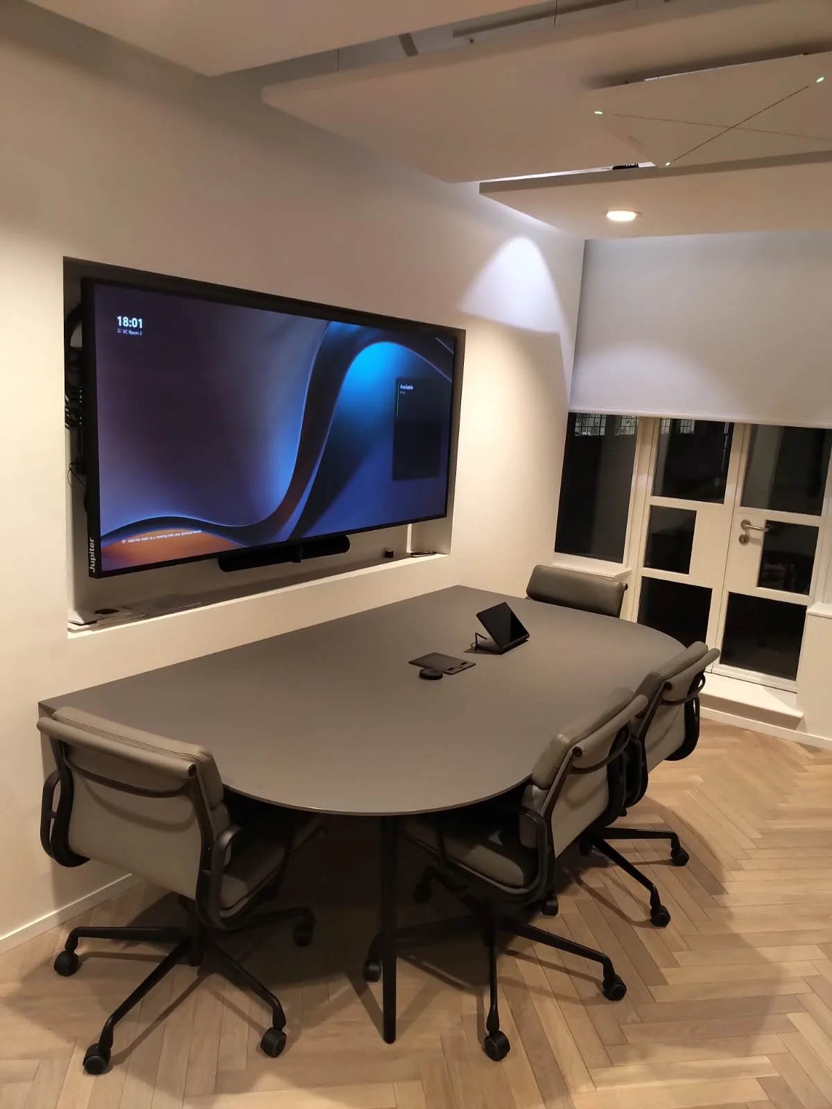 A modern conference room featuring a large television screen and audio-visual solution