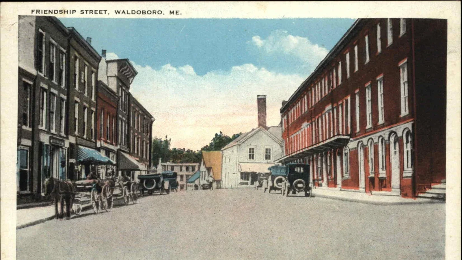 A vintage illustration of Friendship Street in Waldoboro, Maine, showing old brick buildings with storefronts on the left and right sides, several horse-drawn carriages, and a white building with a chimney in the background under a partly cloudy sky.