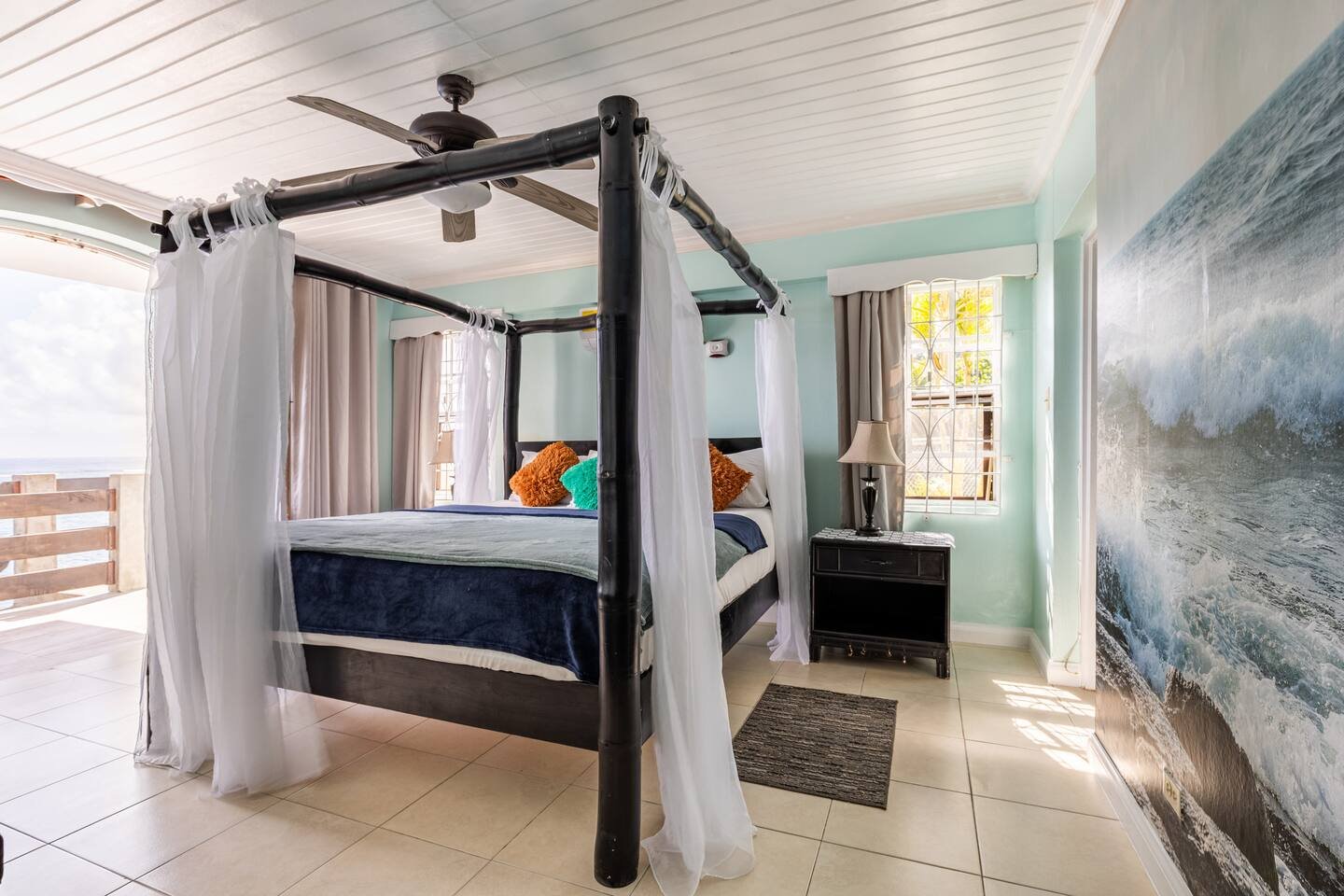 Luxury bedroom with four poster bed and oceanfront view.