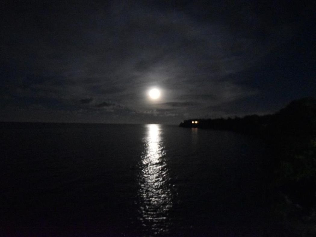 Moonlit ocean with reflections on calm water.