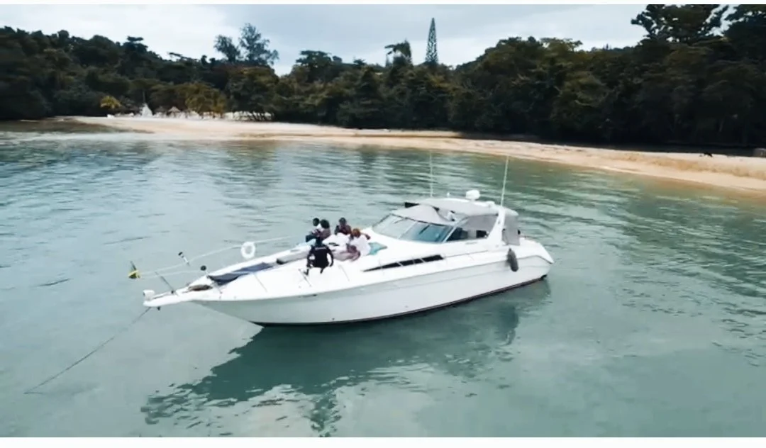 White yacht anchored near a tropical beach.