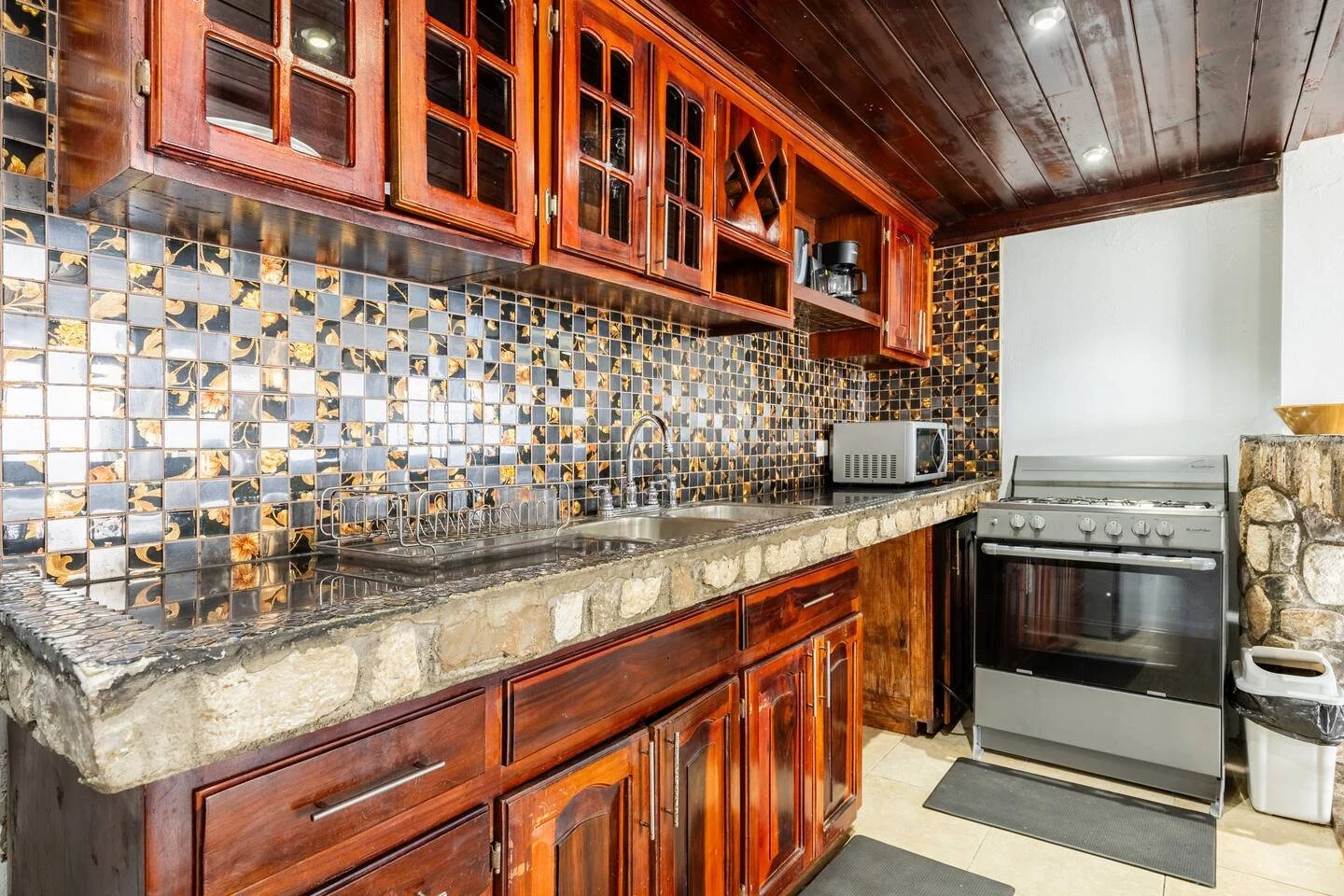 Fully equipped kitchen with wooden cabinets and decorative backsplash.