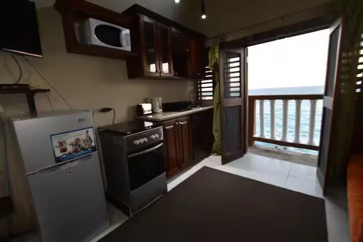 Kitchen with wooden cabinets and ocean-view balcony.