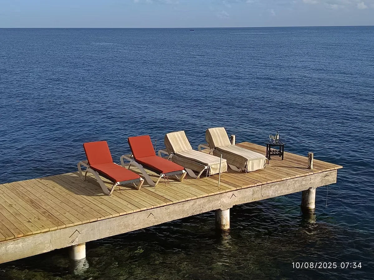 Waterfront pier with lounge chairs overlooking the Caribbean.