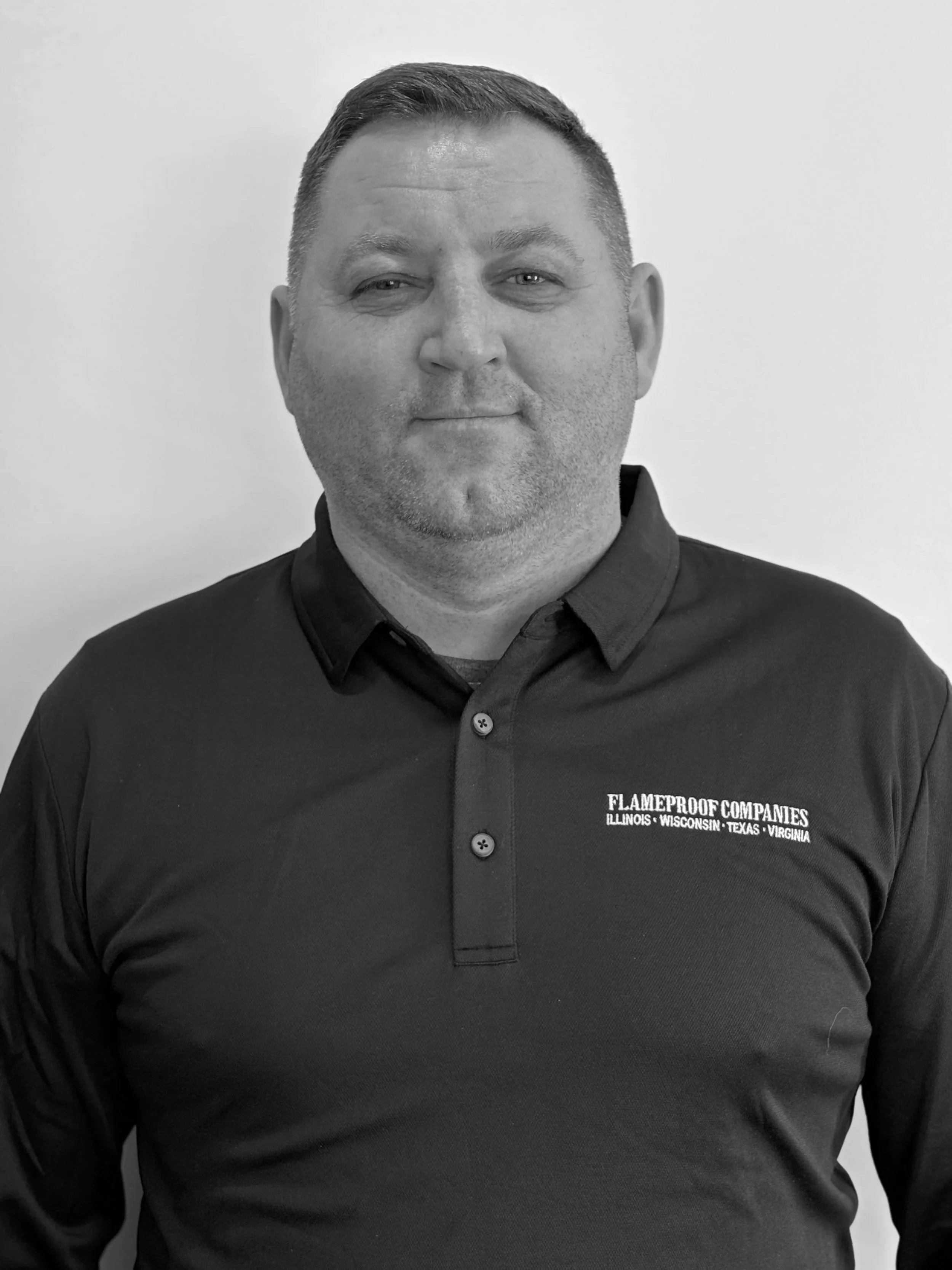 Person standing on snowy hilltop overlooking a valley at sunset with mountains in the background.