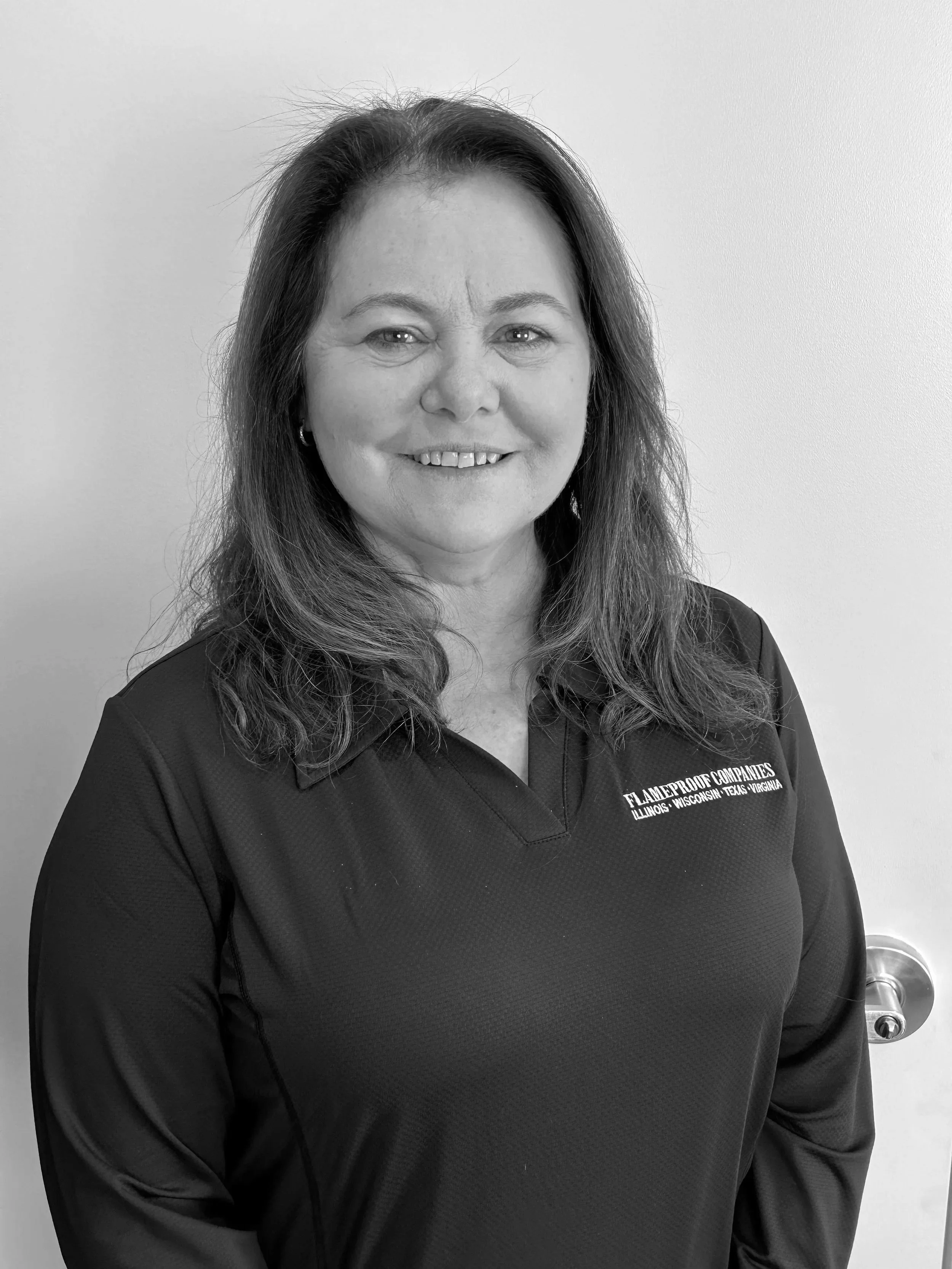 A man in a blue sweater sitting on a beige bench with a neutral background and soft lighting.