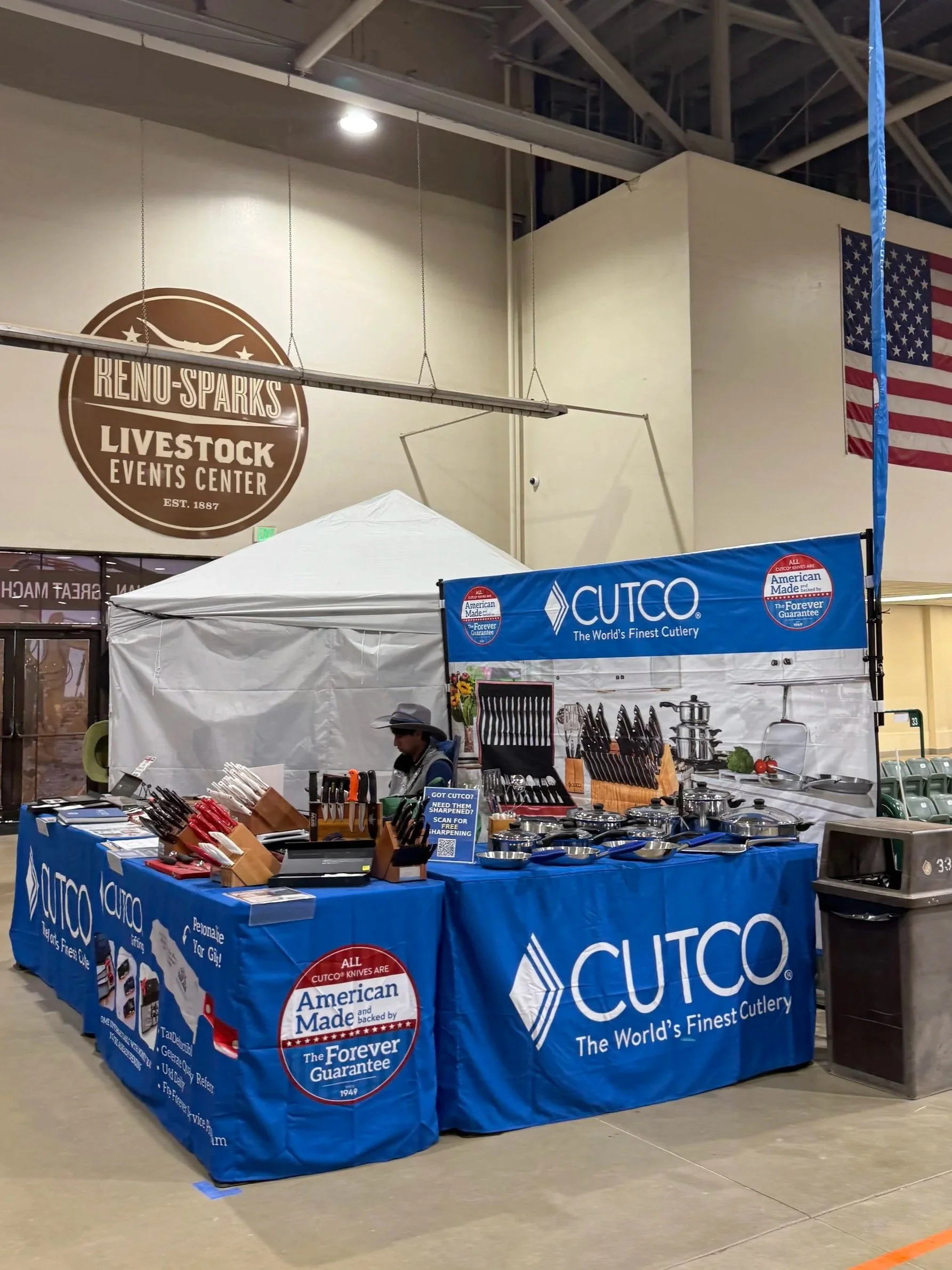 cutco booth with blue table cloths and backdrop