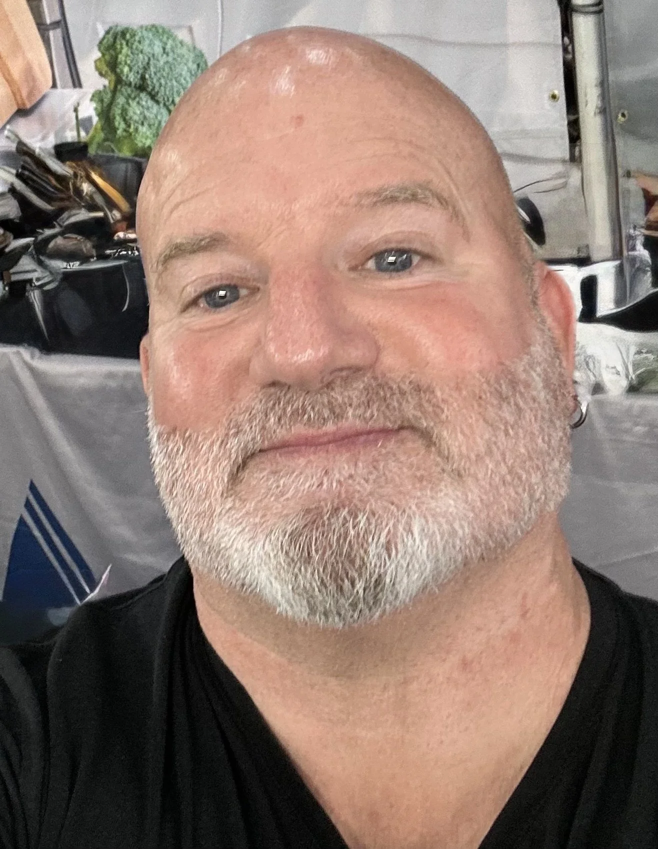 close up smiling man with a white beard and blue eyes, wearing a black shirt