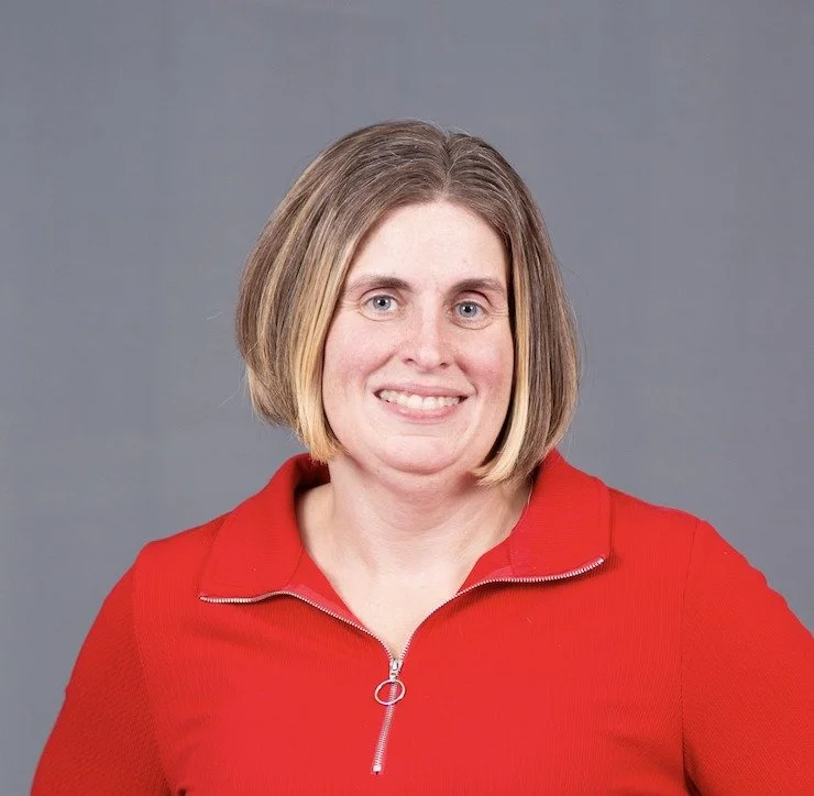 smiling woman with short brown hair and a red shirt