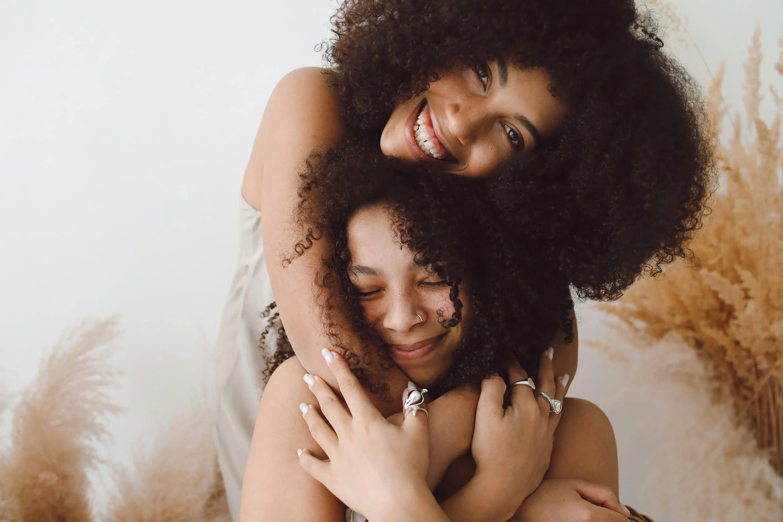 Two girls embracing and smiling after surviving trauma