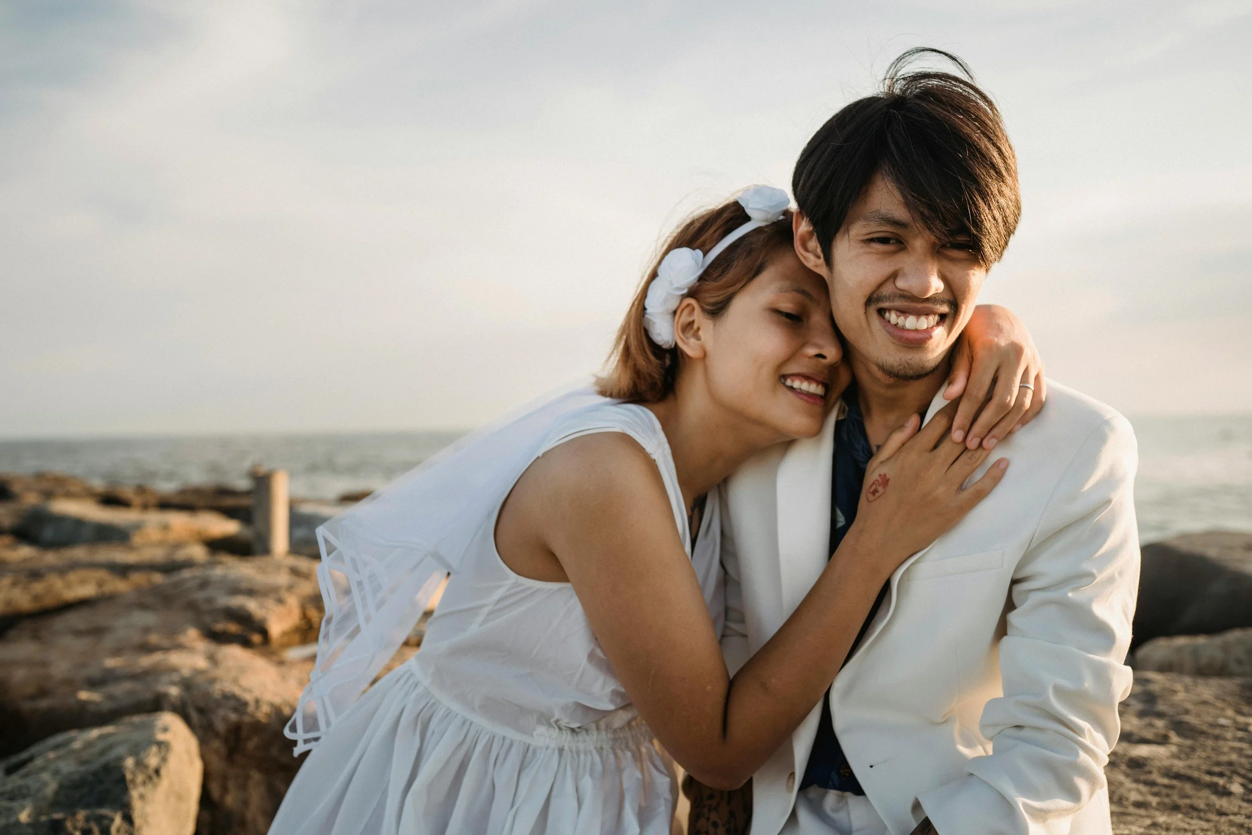 Close-up of a premarital couple's hands wearing wedding rings, holding hands.