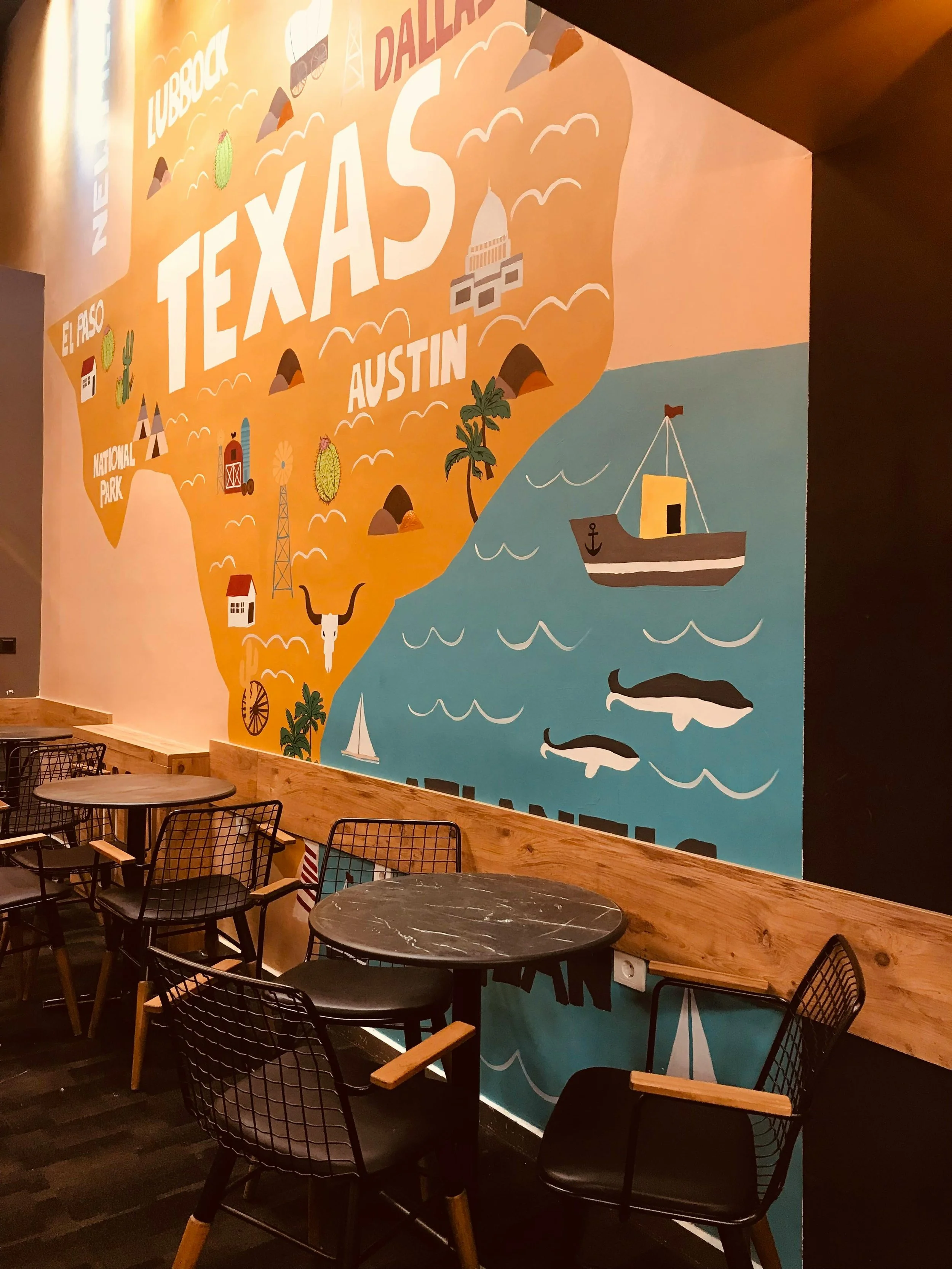 Colorful mural of the Texas map with icons and landmarks, including a boat, whales, and a capitol building. Part of the mural mentions Dallas, Austin, and El Paso.