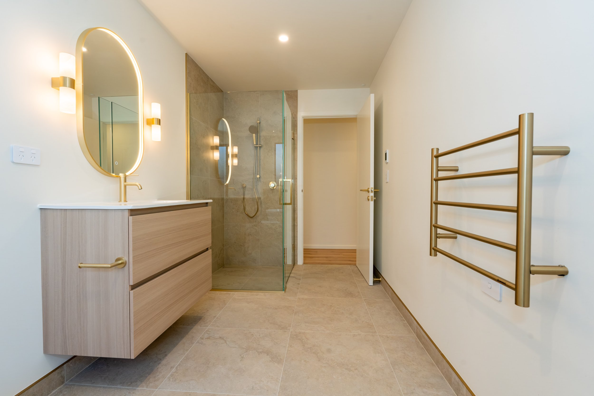 Contemporary main bathroom designed by Nova Design Studio featuring a custom vanity, premium tapware, elegant tiling, and a warm, timeless interior in this Queenstown new build.