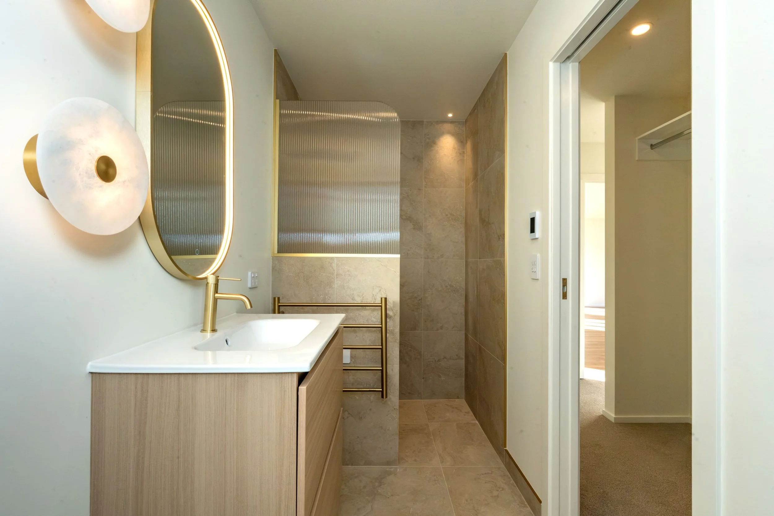 Contemporary ensuite with a custom vanity, high-quality fittings, premium finishes, and a warm neutral palette, designed to create a relaxing and functional bathroom.