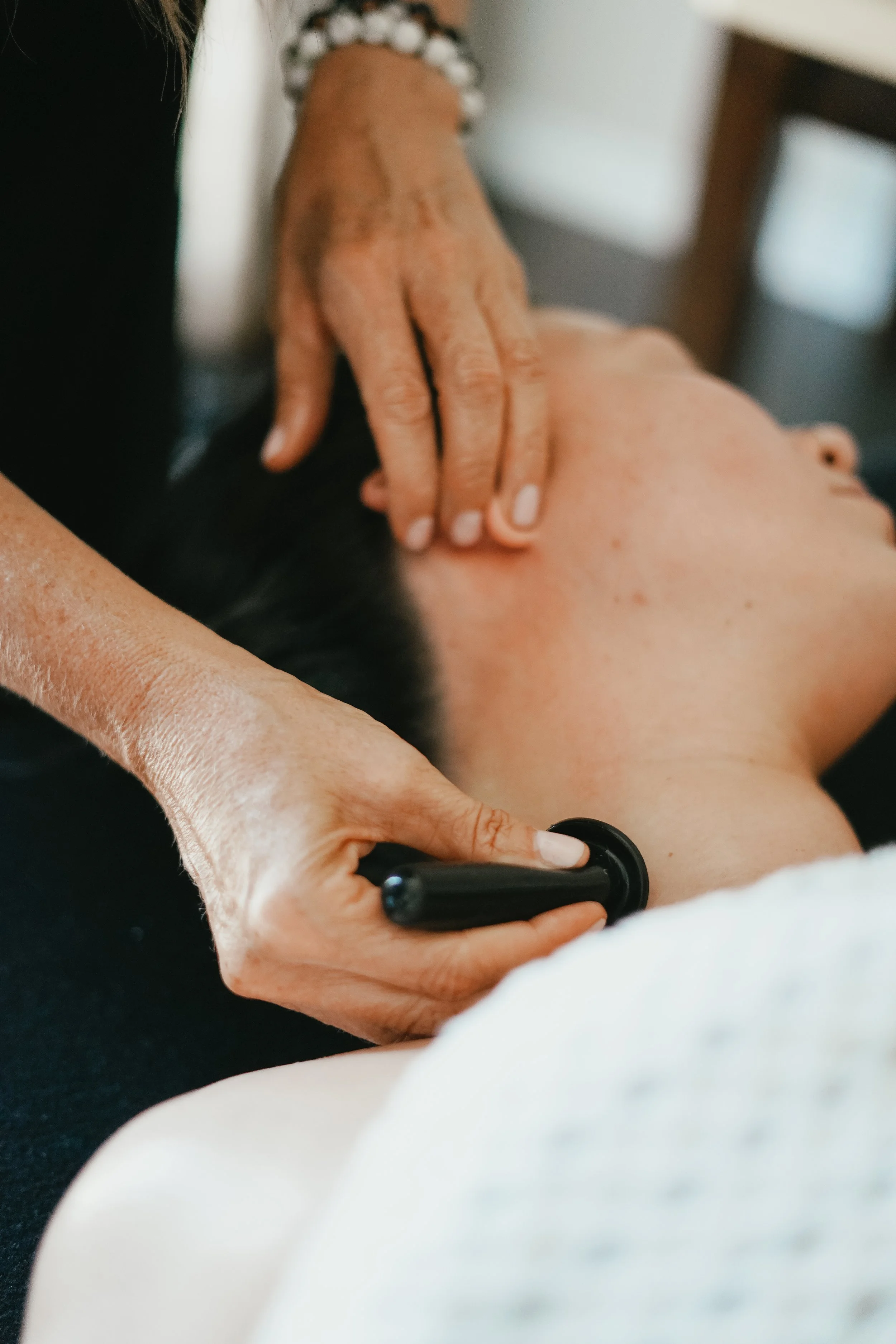 A person receiving a back massage with a massage roller. Booking a glow state facial in stratford ontario.