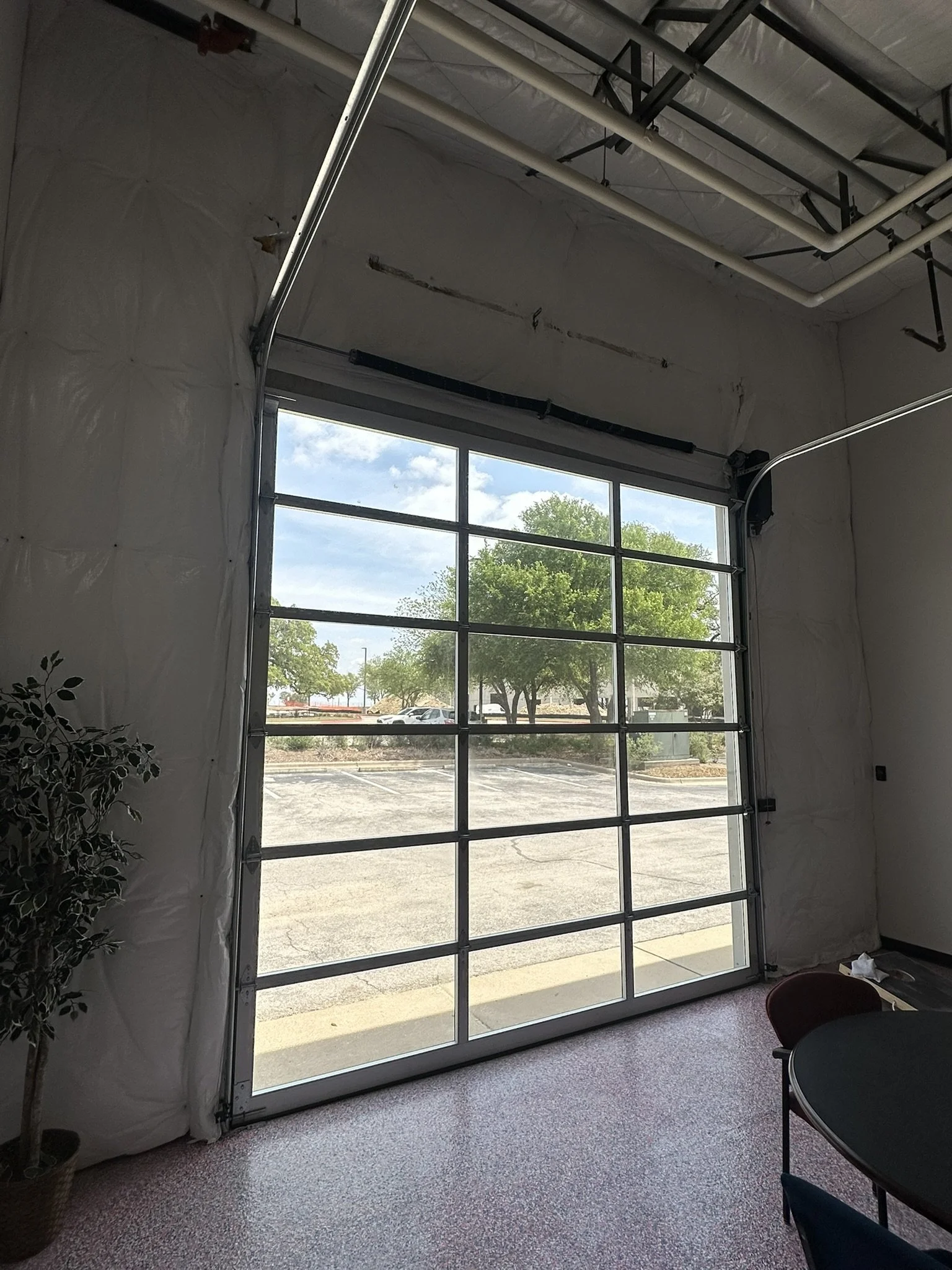 An interior view of a 12x12 fullview garage door. The photo shows how the natural light coming through the door brightens up the entire interior office space.