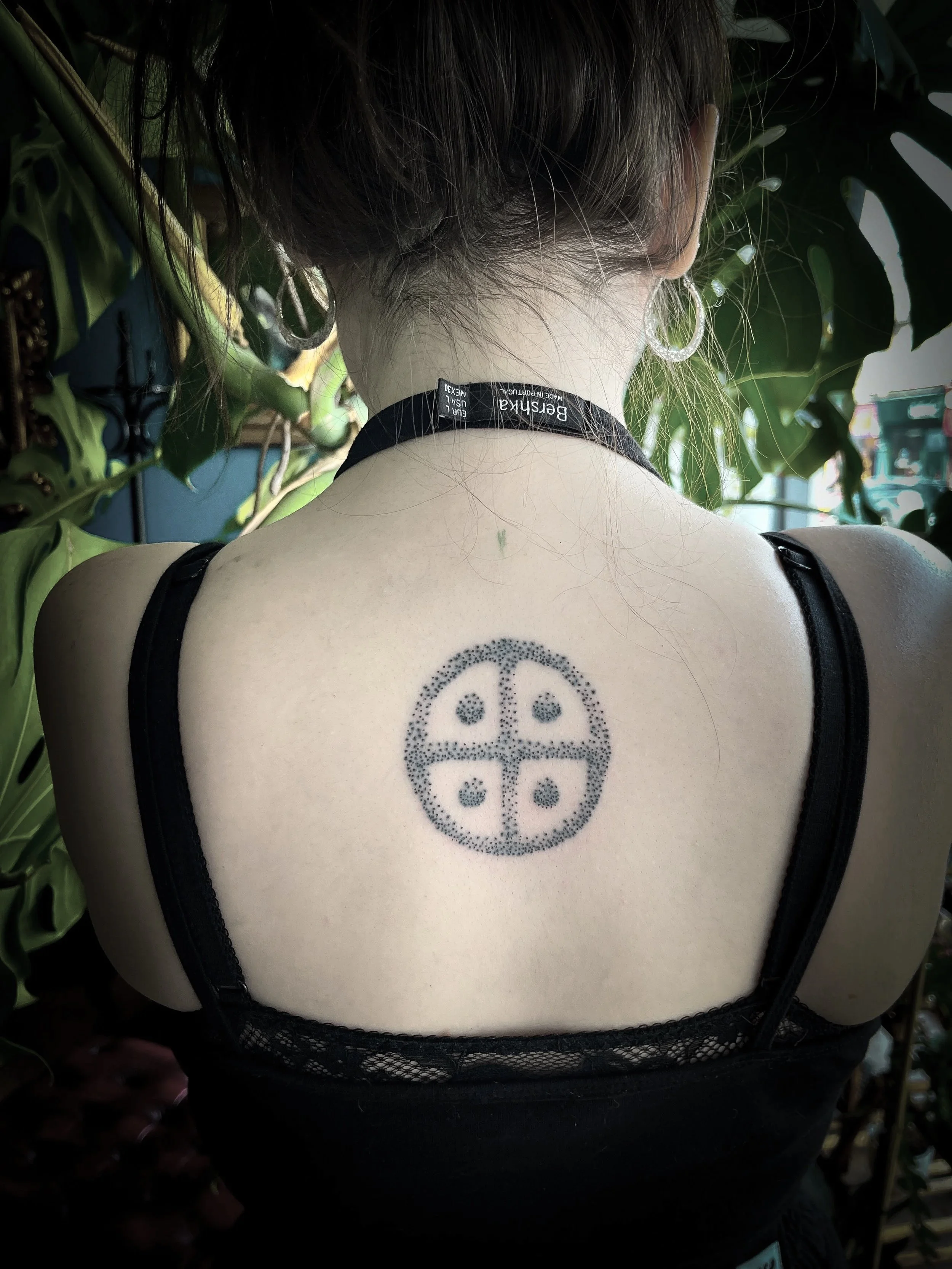 Hand Poked Traditional Tattoo in Cincinnati Ohio done at Stag and Castle in Mt Lookout of a Solar Cross on the back of a beautiful woman 