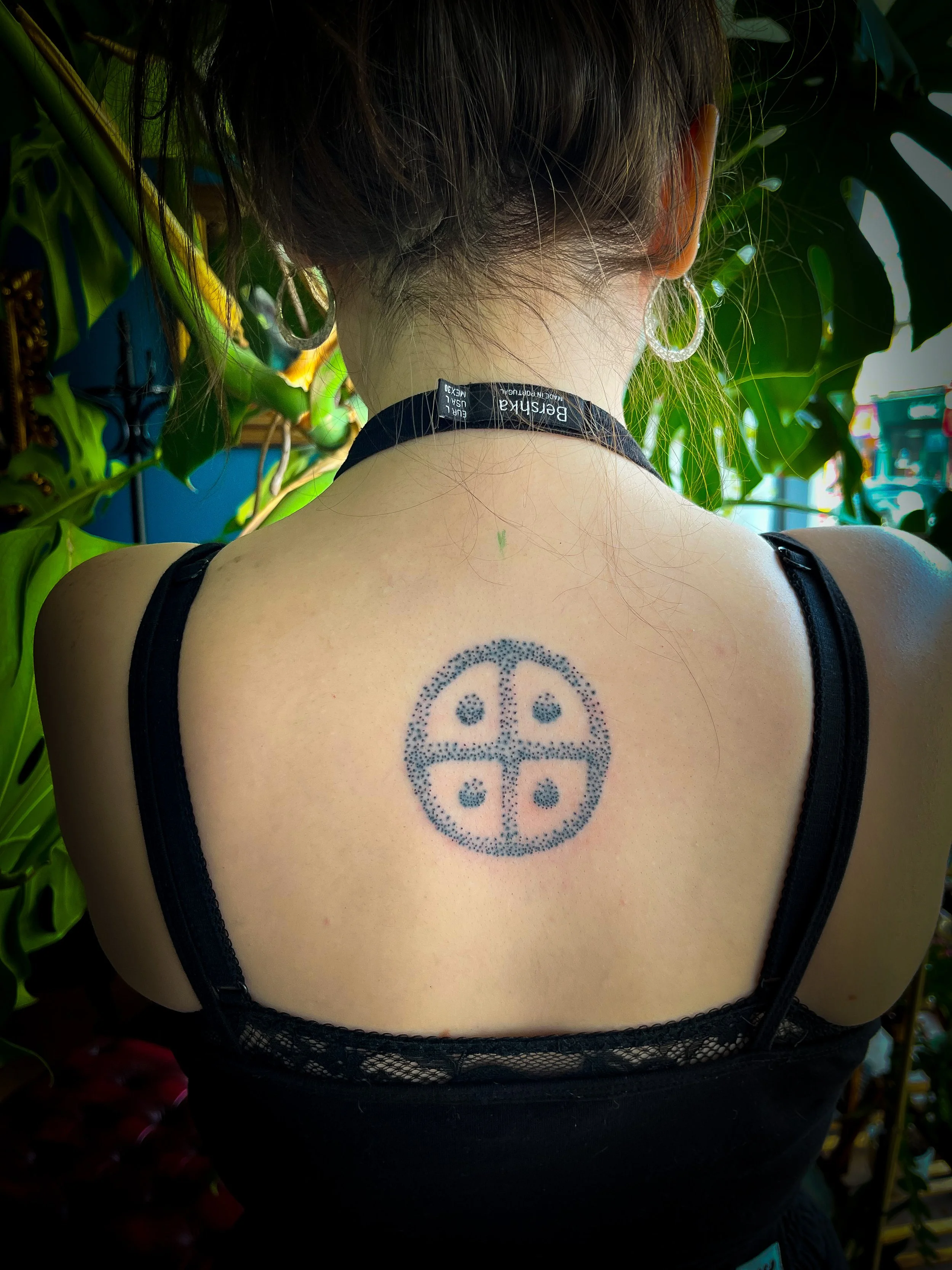Hand Poked Traditional Tattoo in Cincinnati Ohio done at Stag and Castle in Mt Lookout of a Solar Cross on the back of a beautiful woman 