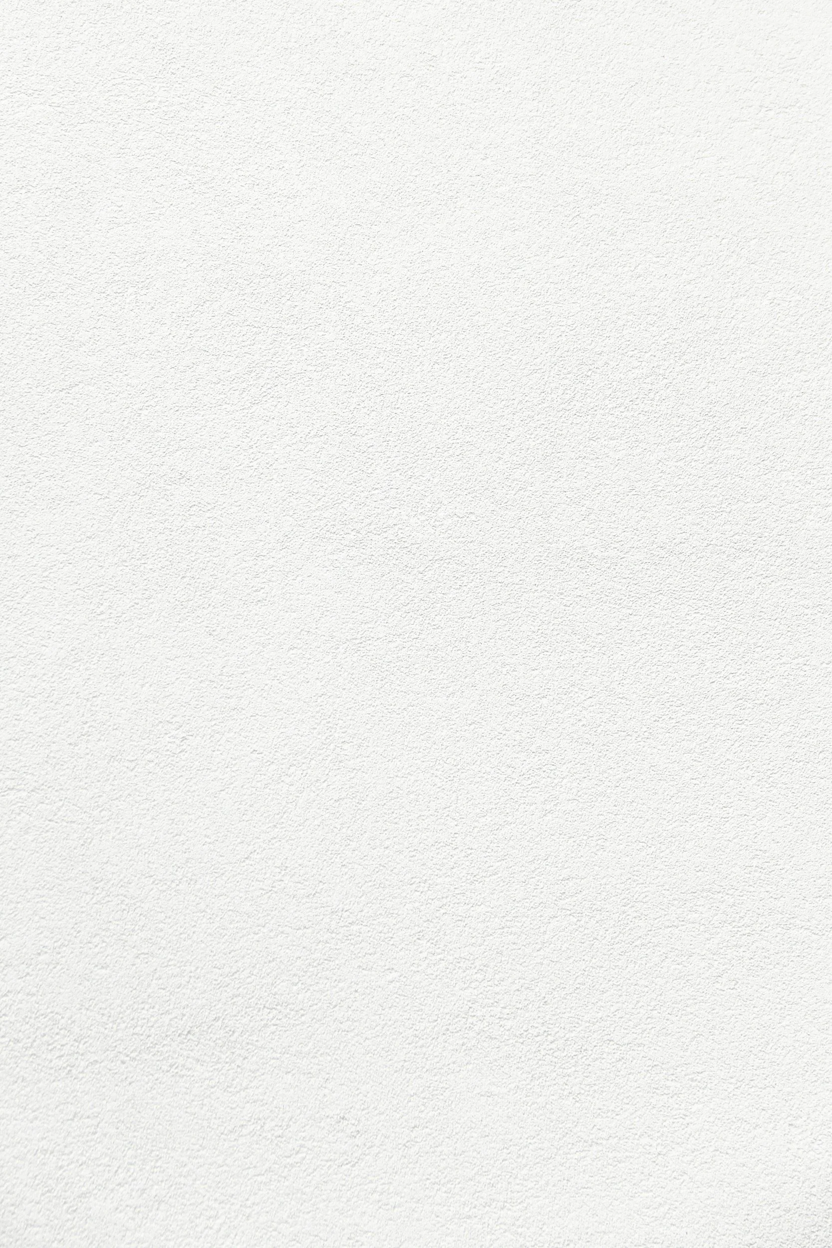A blank white textured wall.