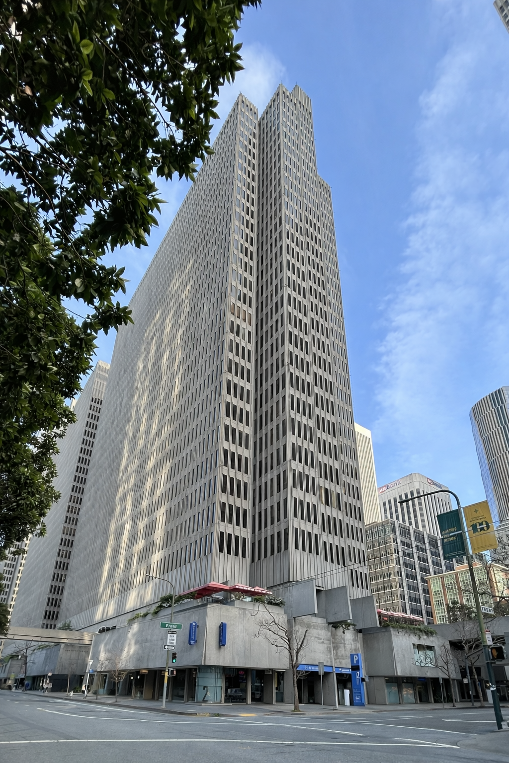 Two Embarcadero, San Francisco - a tall modern office building with a unique stepped design, surrounded by other skyscrapers, seen under a blue sky. Some interior office structural engineering by BASE Design.