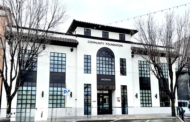 White modern building with black window frames labeled 'Community Foundation' and 'Epicenter', surrounded by leafless trees. Structural engineering by BASE Design in San Francisco.