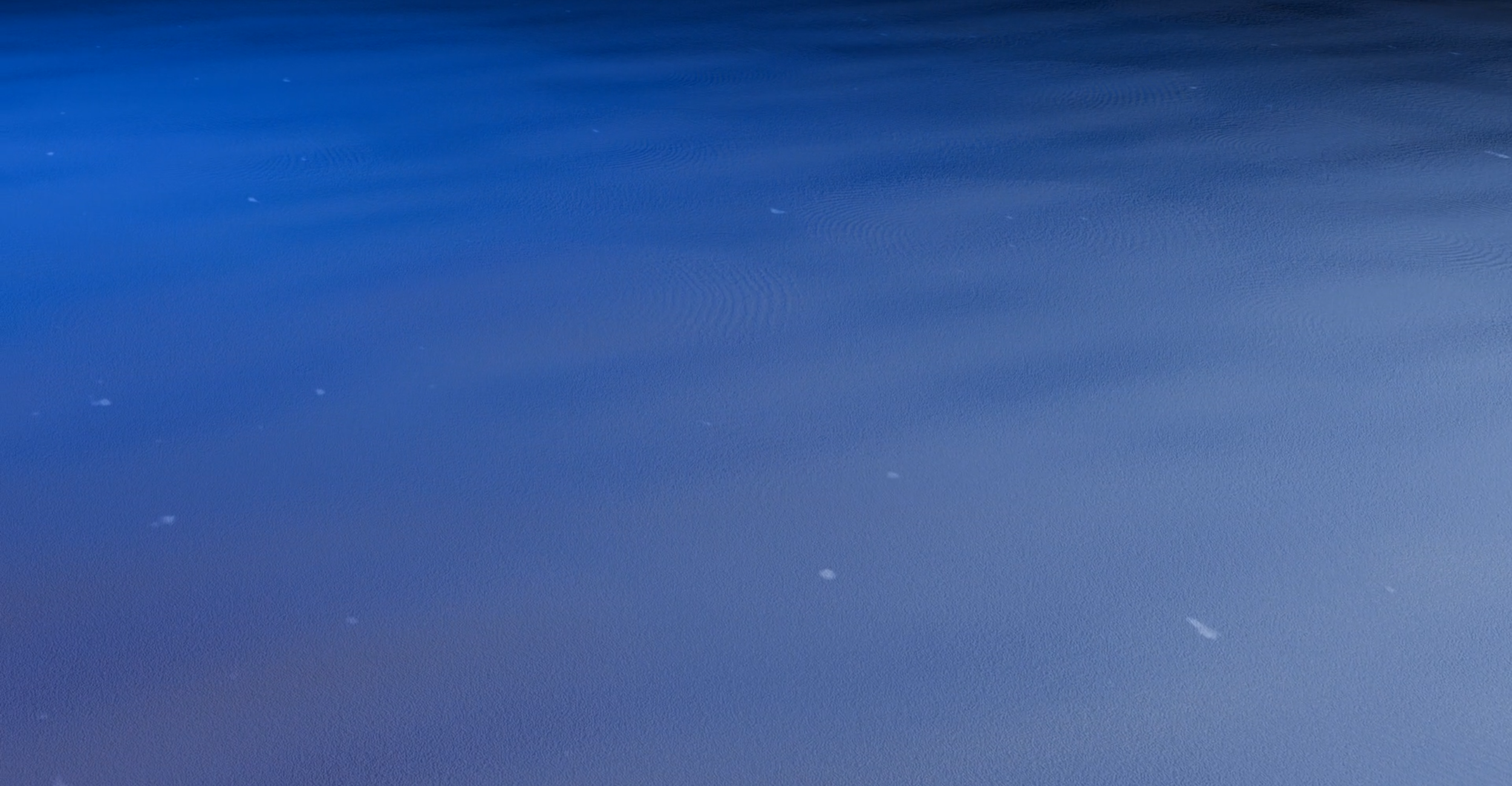 Close-up of a snow-covered surface with small snowflakes falling.