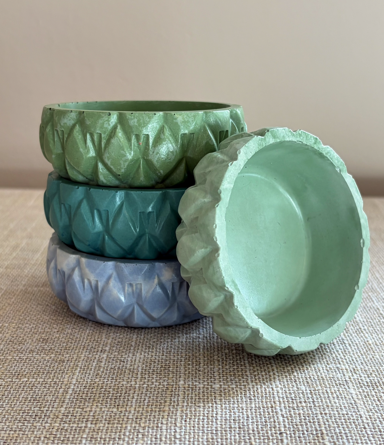 Stack of multi-colored green/blue round jars