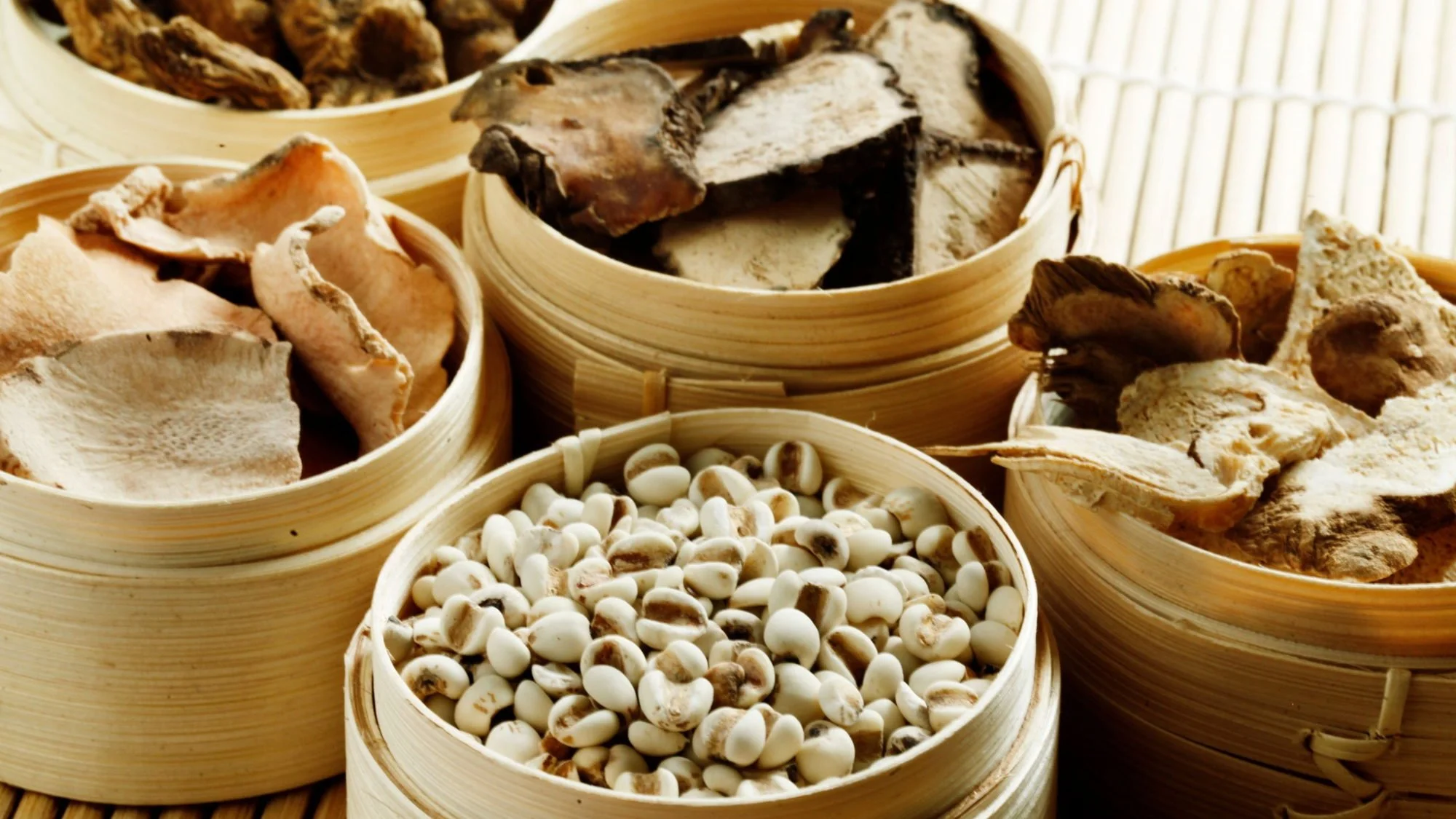 Bamboo steamers of dried mushrooms, seeds and herbs used in traditional Chinese autumn cooking