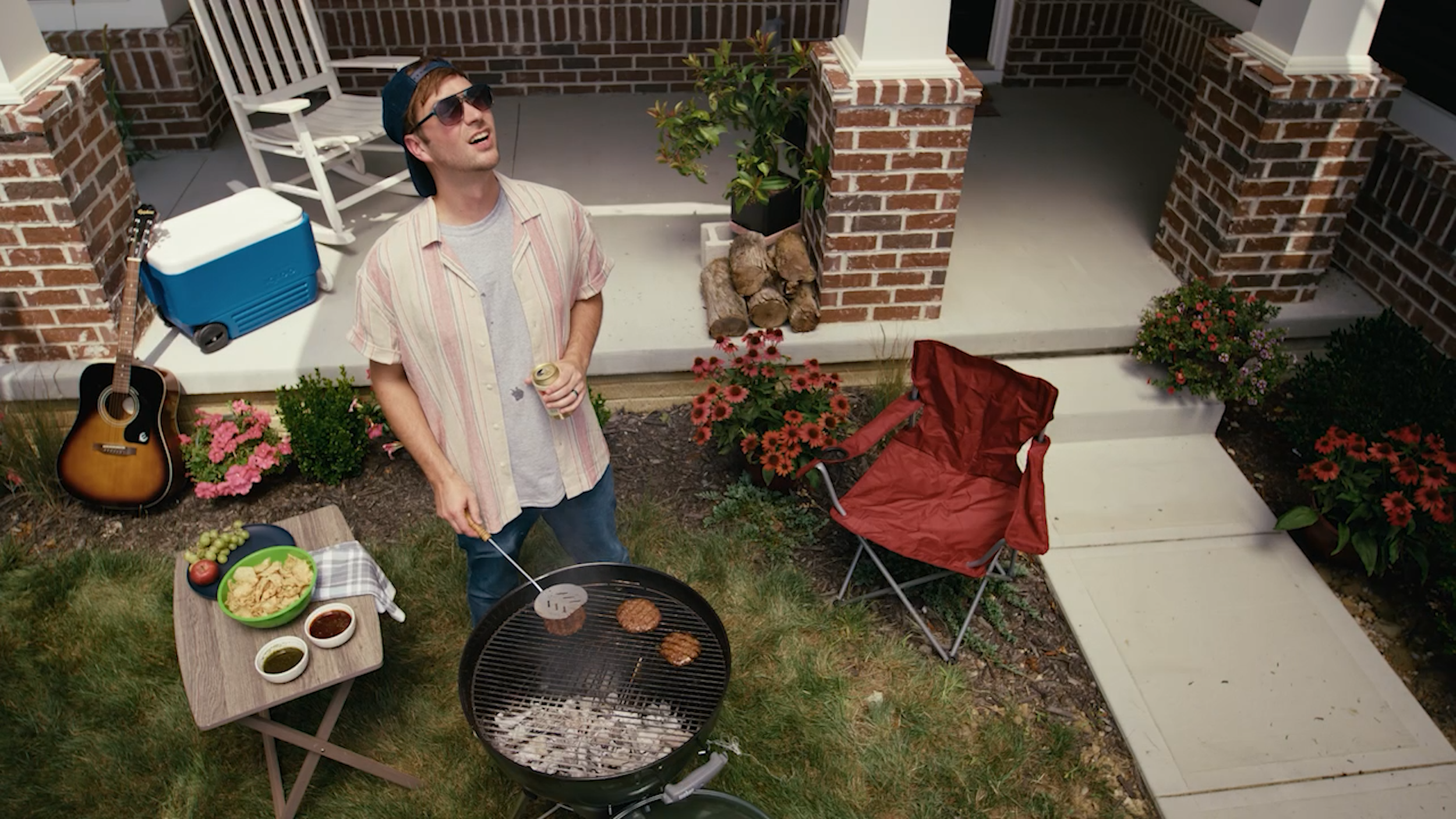 Lifestyle campaign frame of a man grilling outdoors during an Ember & Frame brand shoot