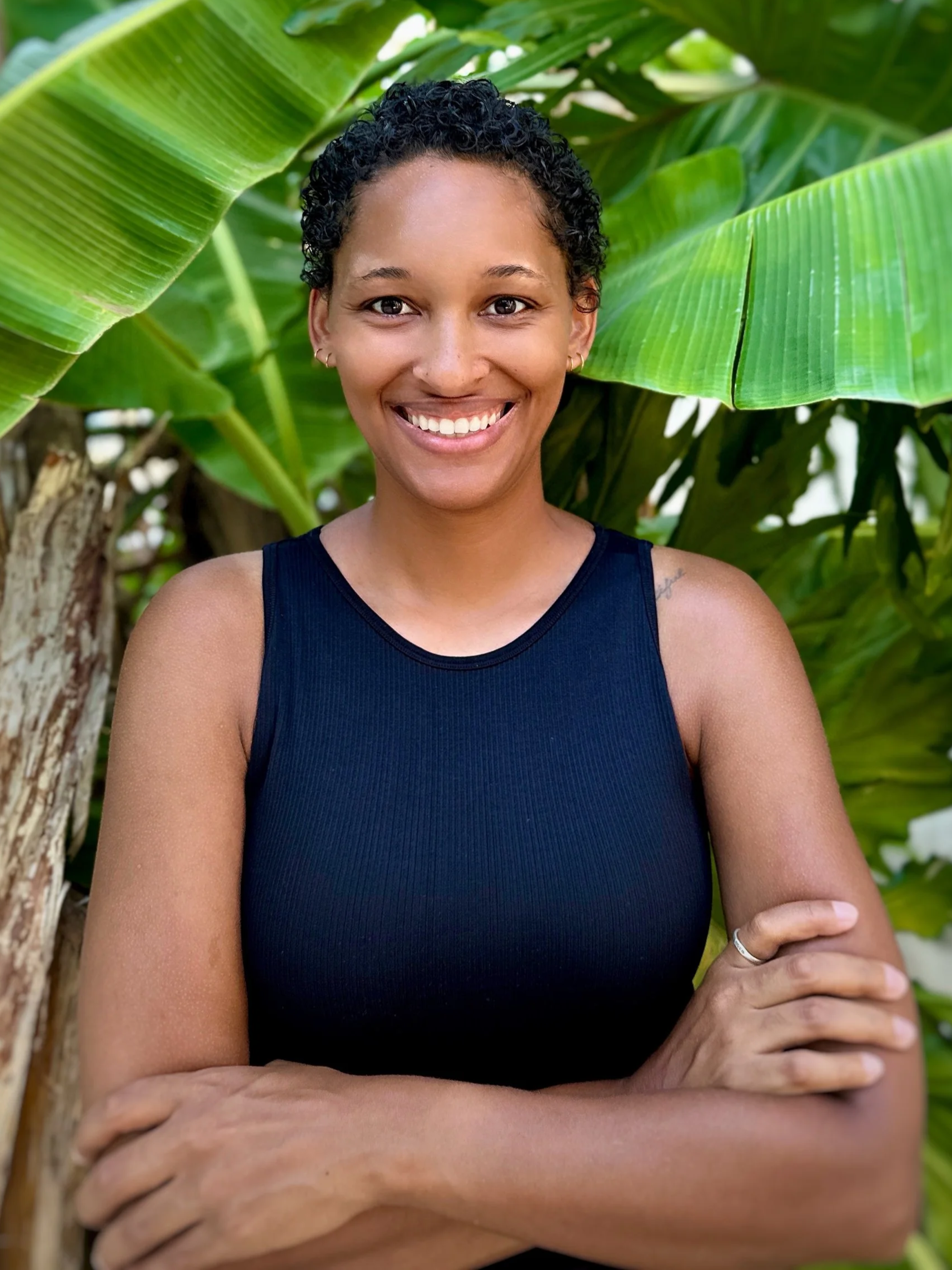 A human hand held up with fingers slightly spread, casting a shadow on a wall with striped sunlight.