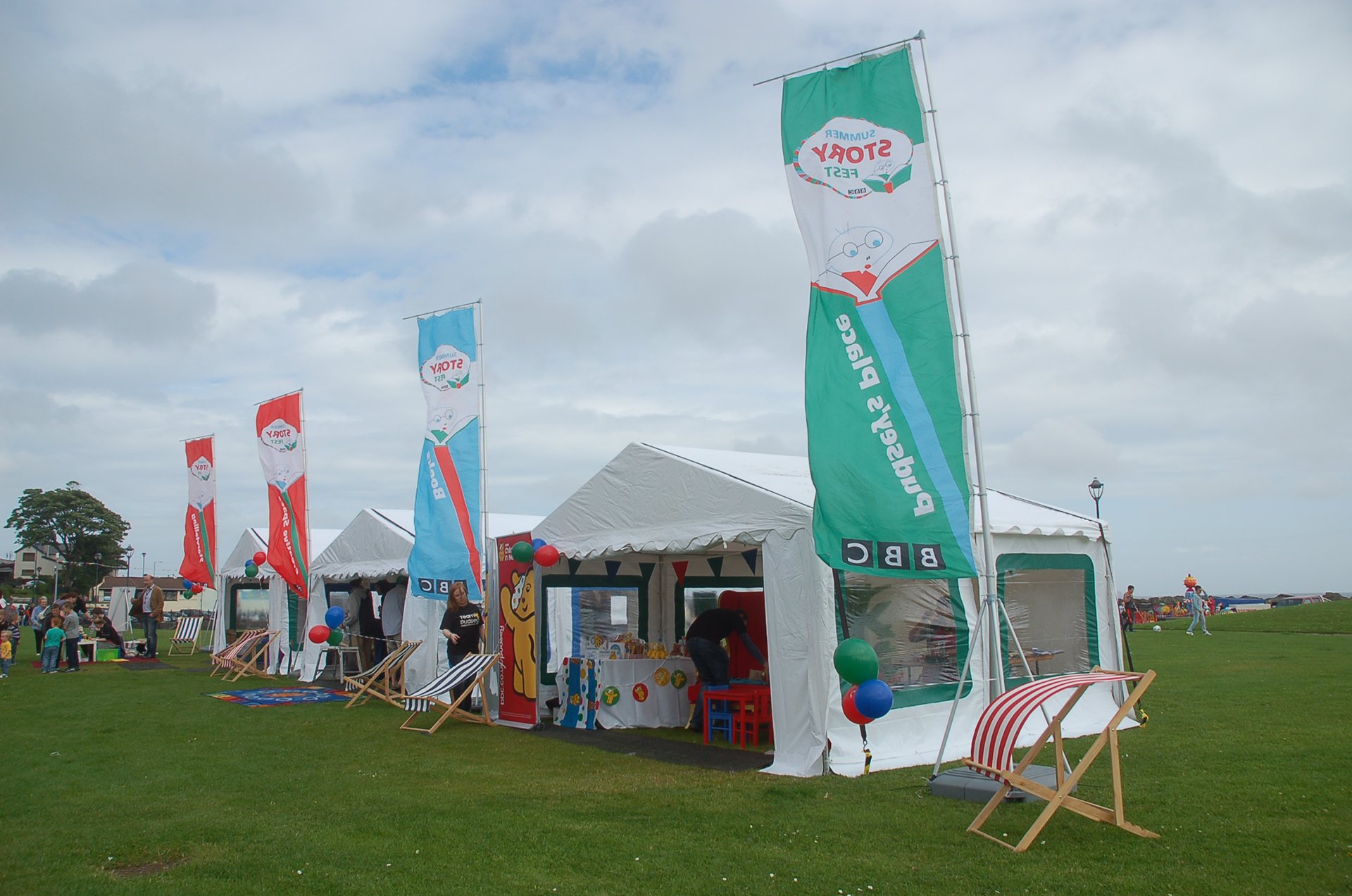 Event flags flying 4m high with event marquees in the background.