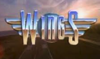 Giant metallic sign spelling 'WINGS' with a sunset background