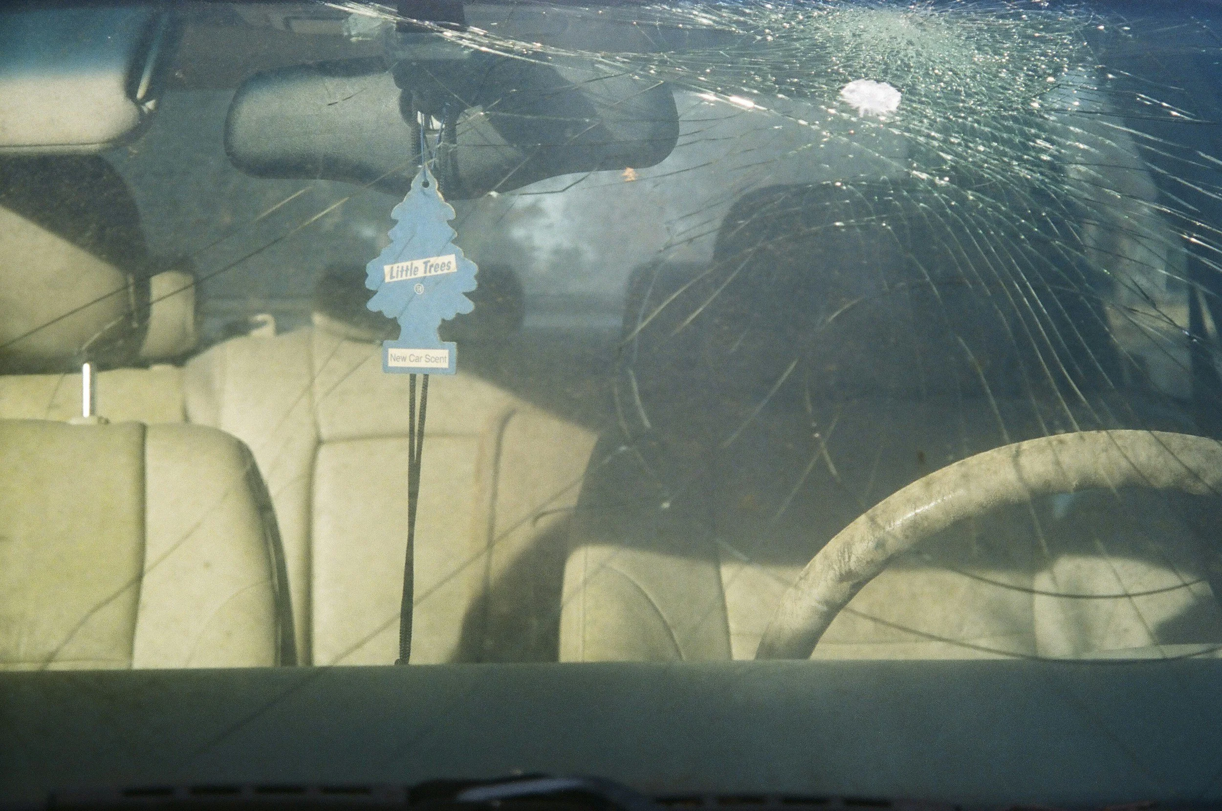 View of the inside of a car with shattered windshield glass.