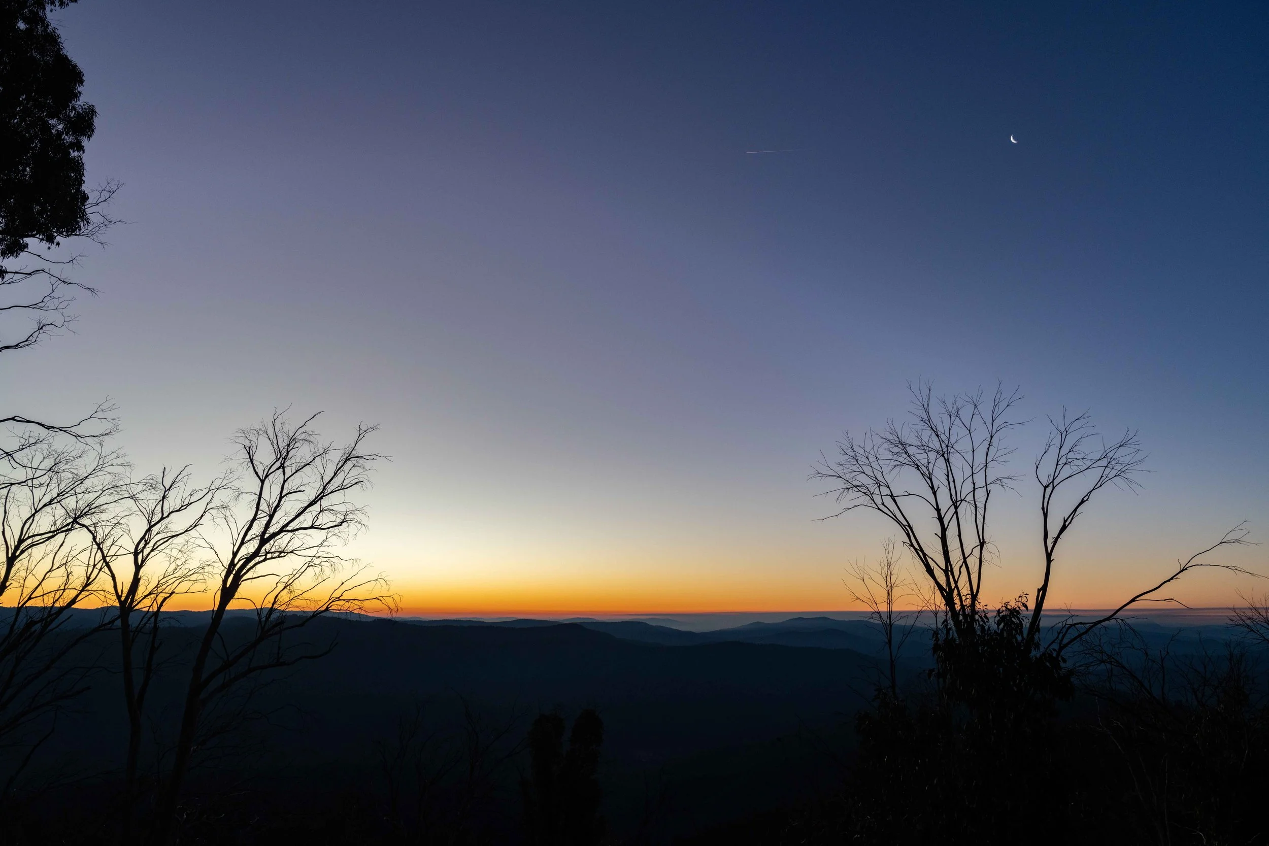 A late evening sunset is pictured with stars beginning to peek through and the colours ranging from orange to purple. Captured by photographer Ian Grant. 