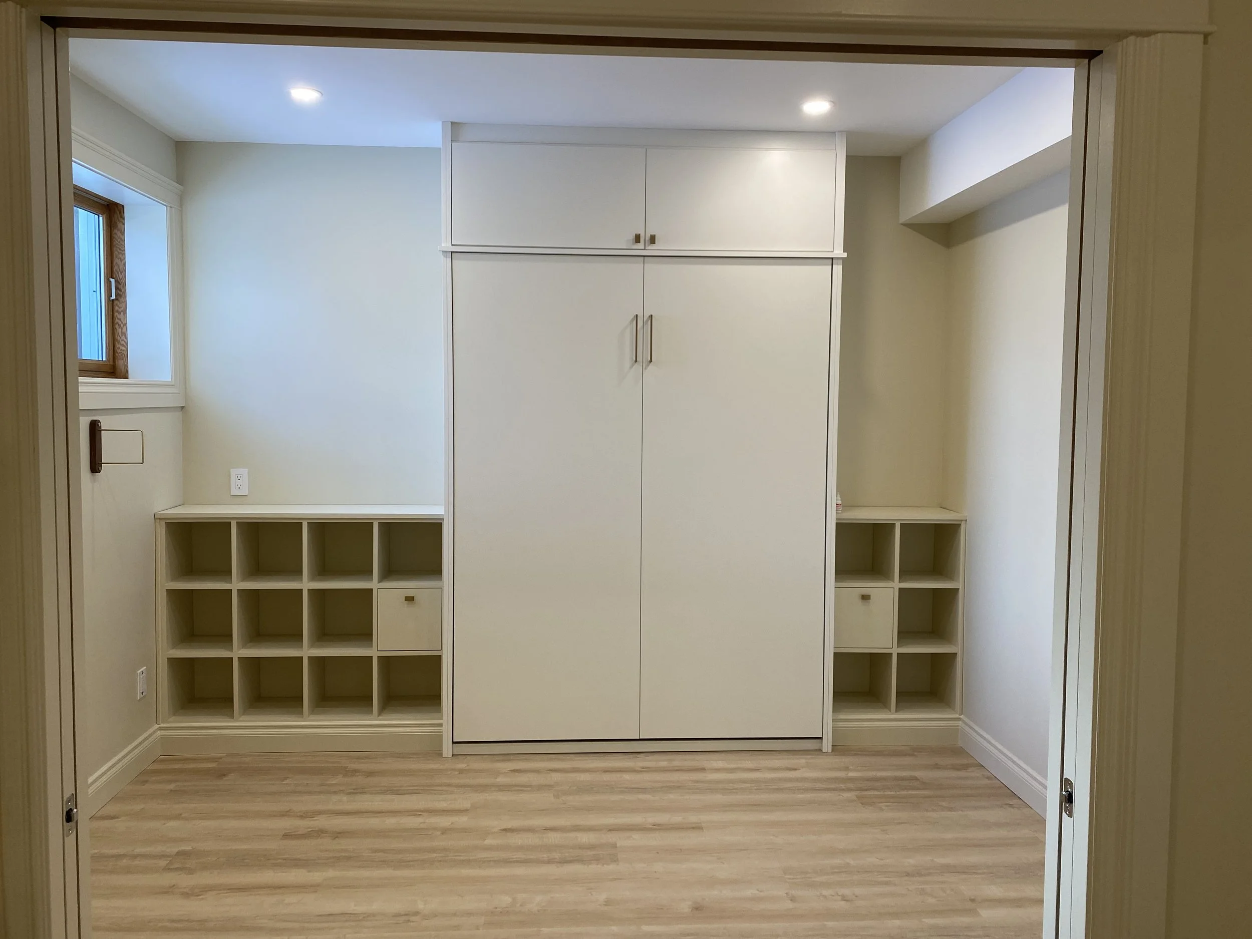 Custom storage and fold down night stand tables in multi-purpose room.