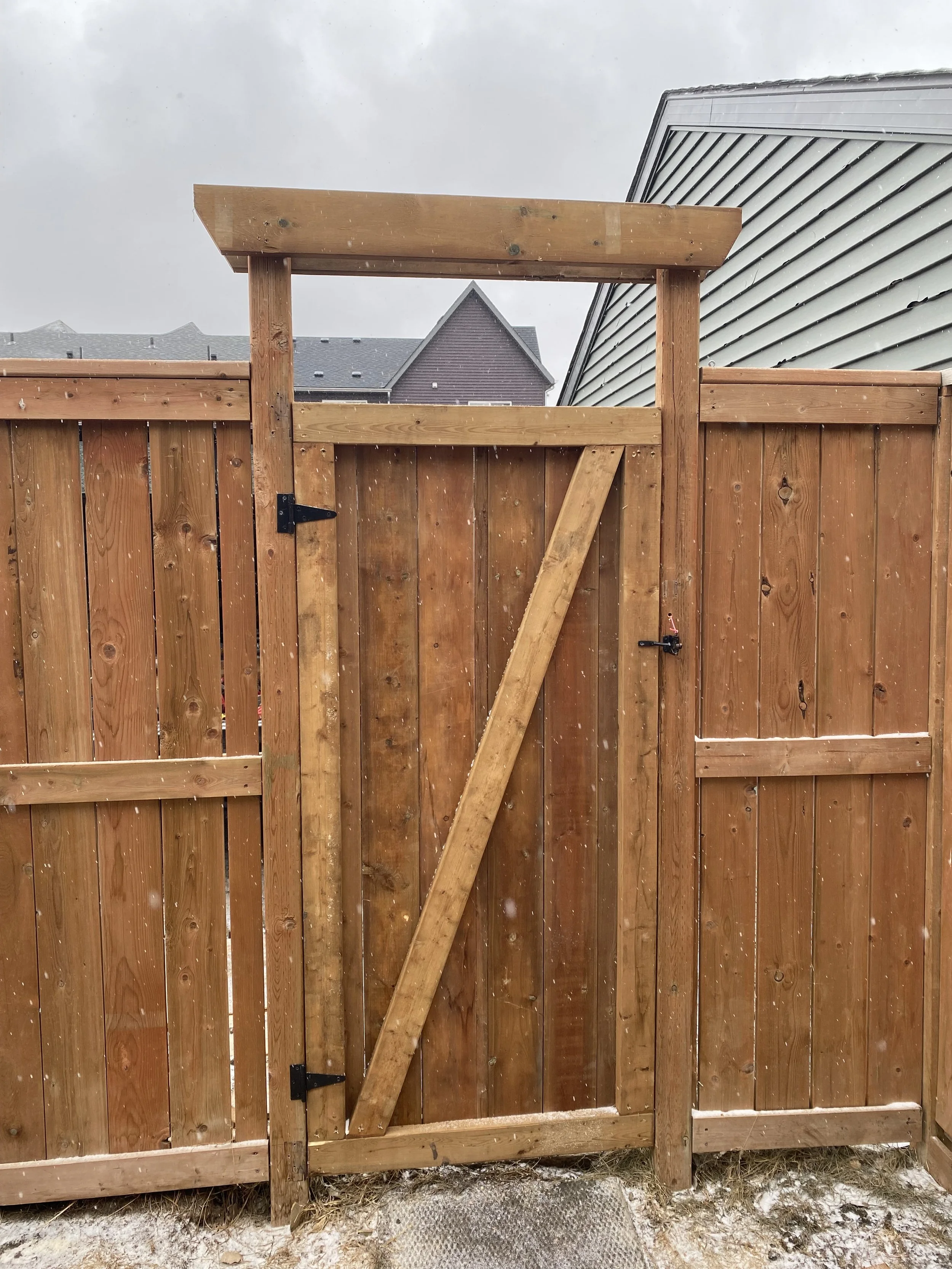Rebuilt builder-grade sagging gate with new, braced, strong, treated lumber gate.