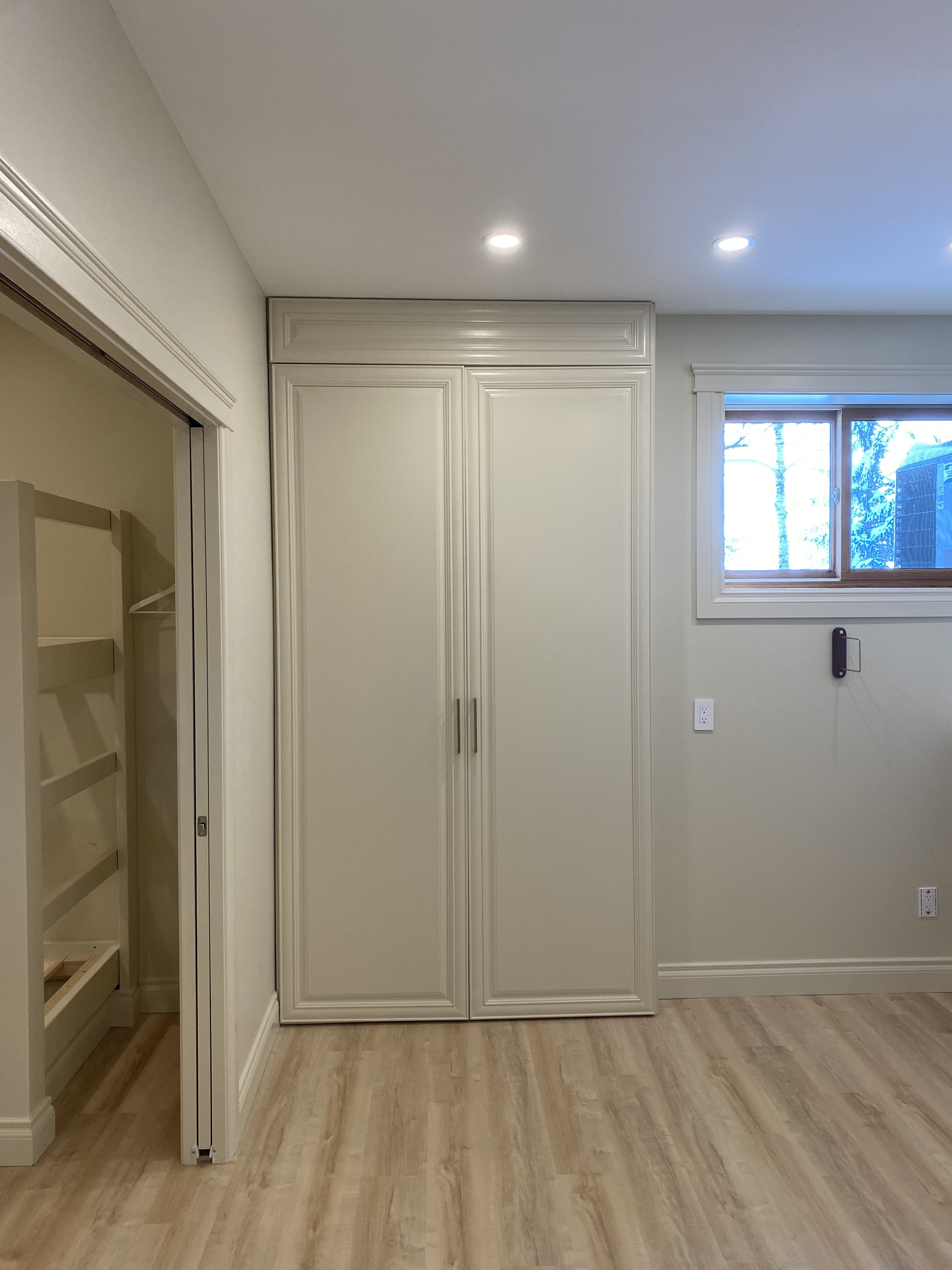 Custom cabinet doors and header to cover electrical panel.