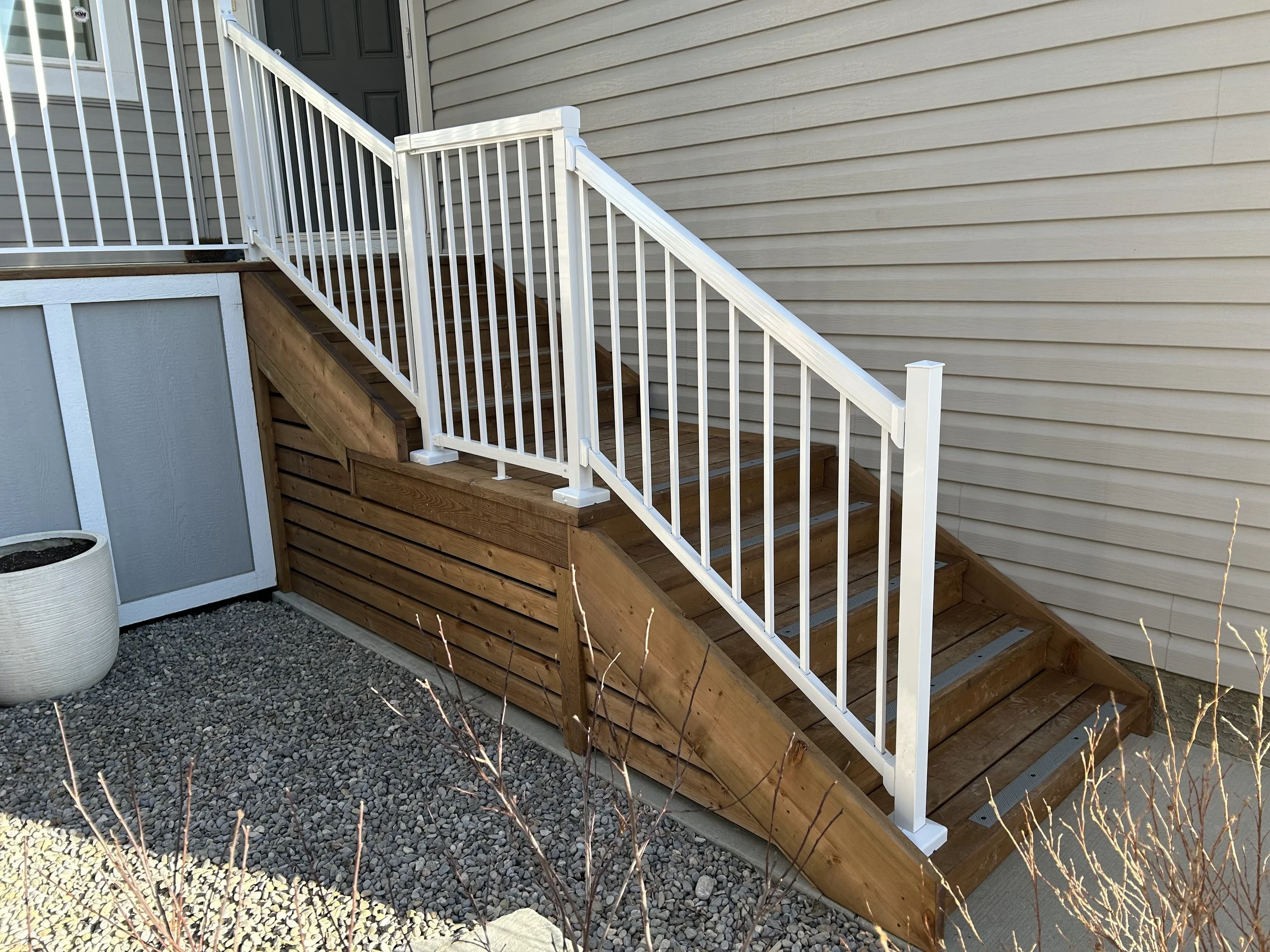 After pic of custom stairs with low rise with mid-level landing, railing and skirting.