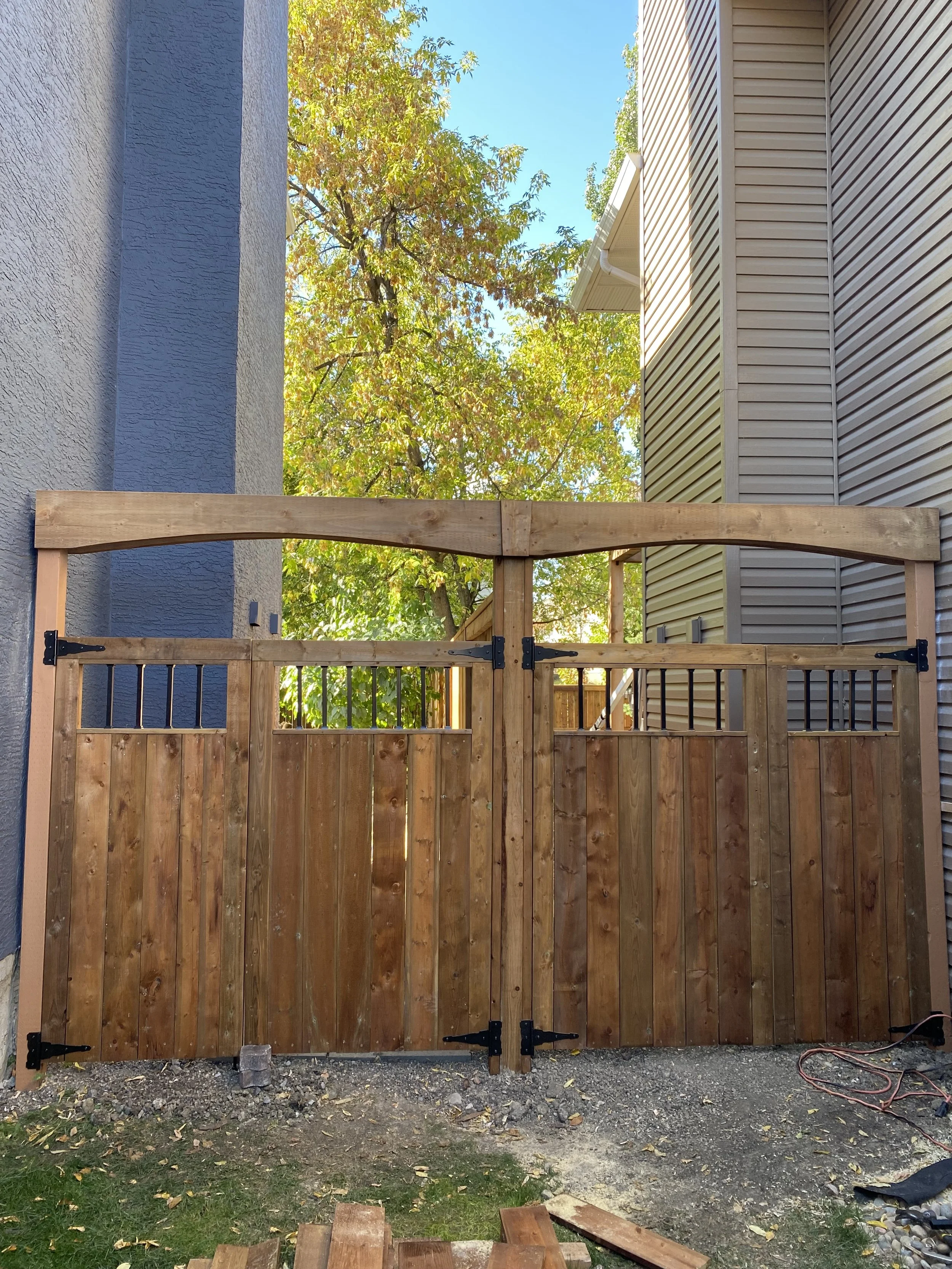 Custom neighbour-friendly twin double gates from treated lumber for secure, safe yard access.