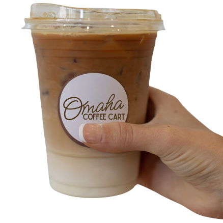 A hand holding a cold foam and iced coffee drink in a clear plastic cup with a white logo label that says "Omaha Coffee Cart."