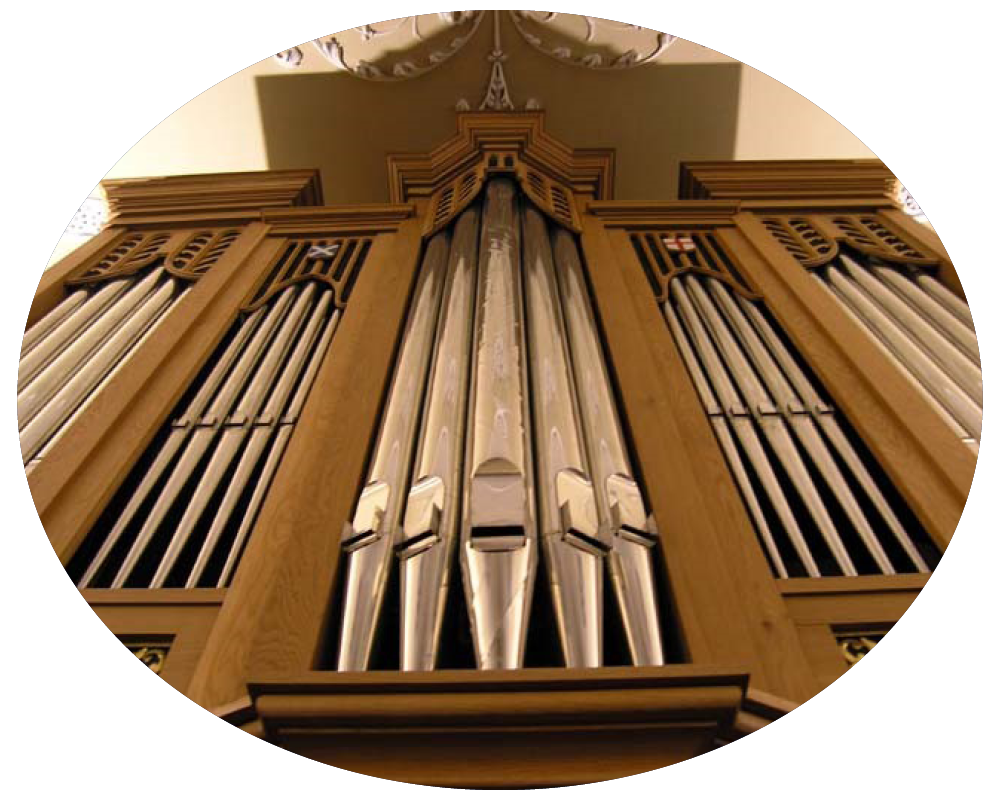 View from below of a wooden pipe organ with silver pipes in a church.