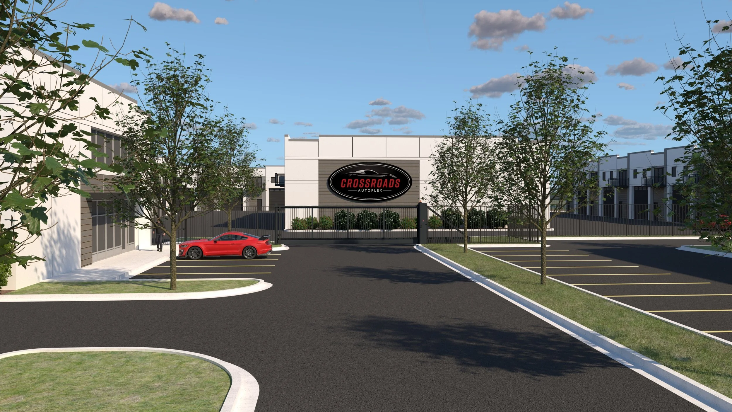 Entrance rendering of The Crossroads Autoplex with gated driveway, Crossroads Autoplex sign, and on-site parking.