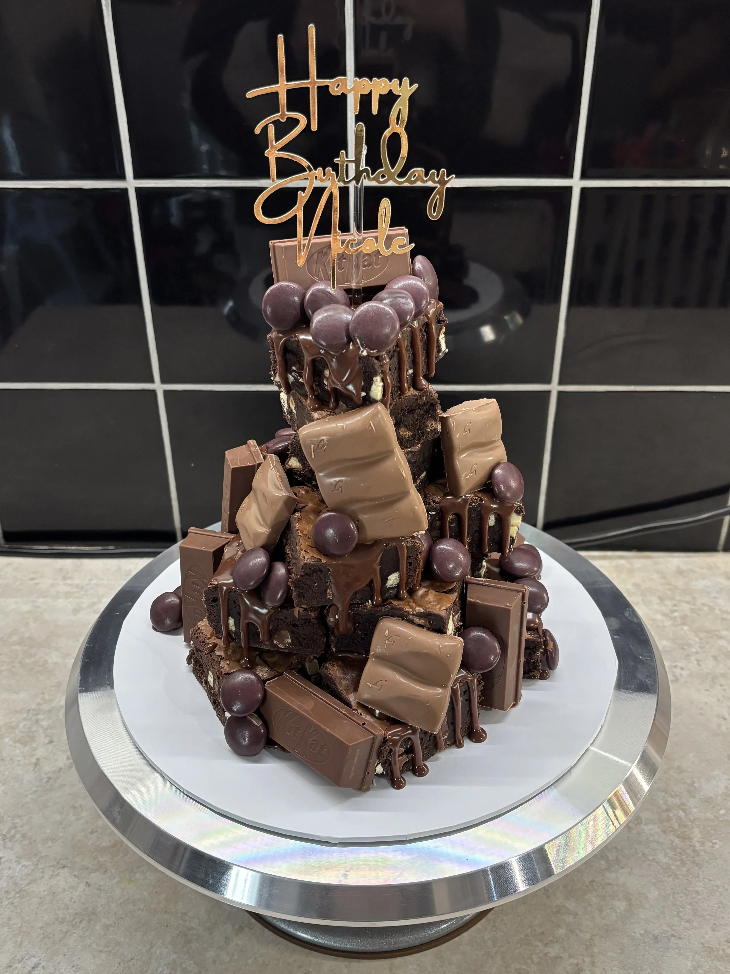 Chocolate birthday cake decorated with various chocolates and topped with a 'Happy Birthday Hale' cake topper.