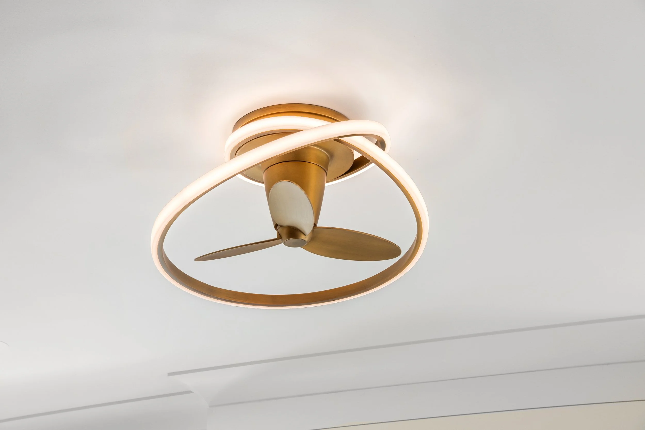Modern ceiling fan with integrated LED light fixture in a white ceiling.