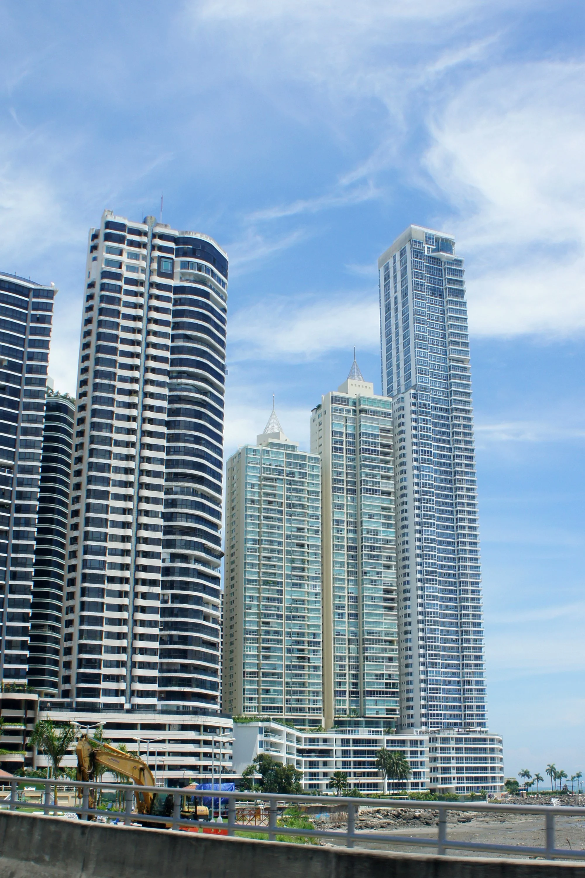 Rascacielos modernos en una ciudad costera, con estructuras altas de cristal y un cielo despejado.