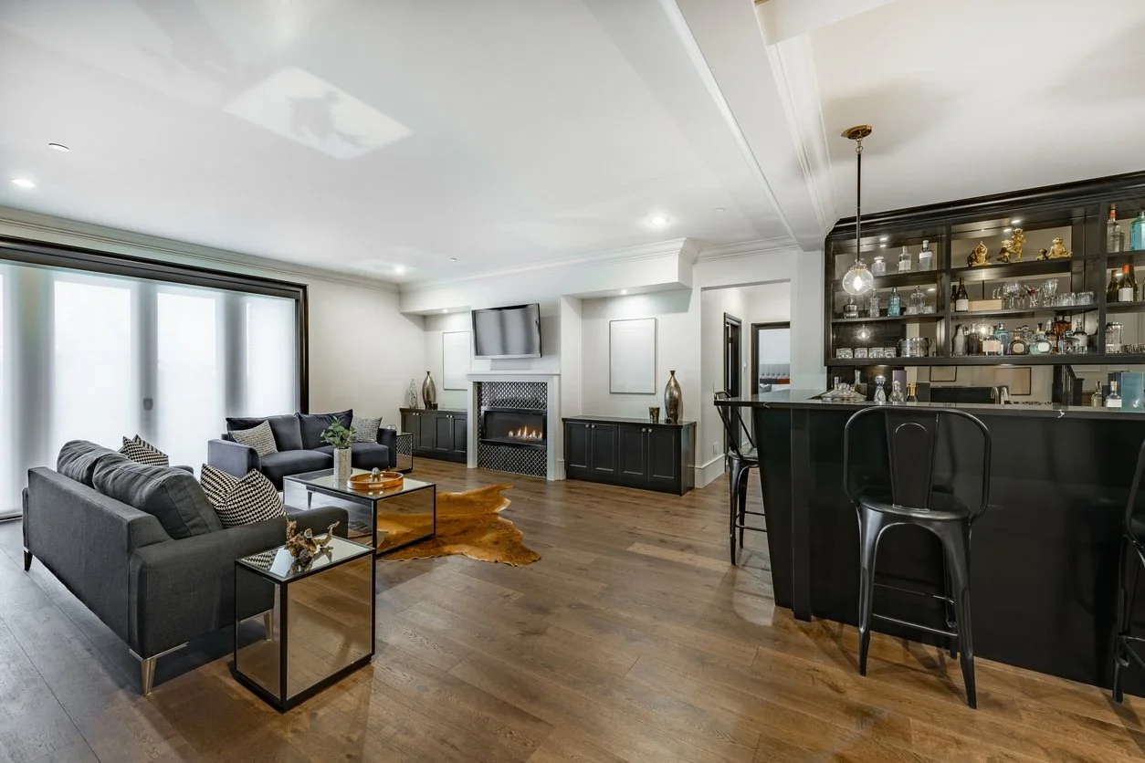 Sophisticated living room featuring a built-in home bar, highlighting the custom spaces, staffing coordination, and lifestyle-focused property management we provide.