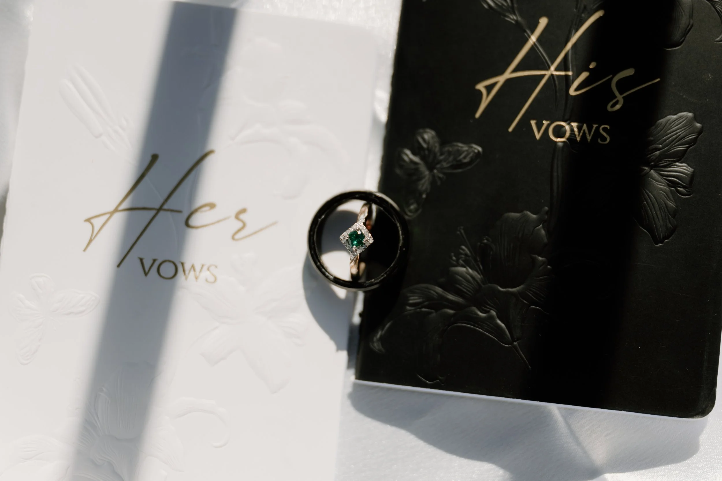A detail shot of elopement vow books and engagement rings