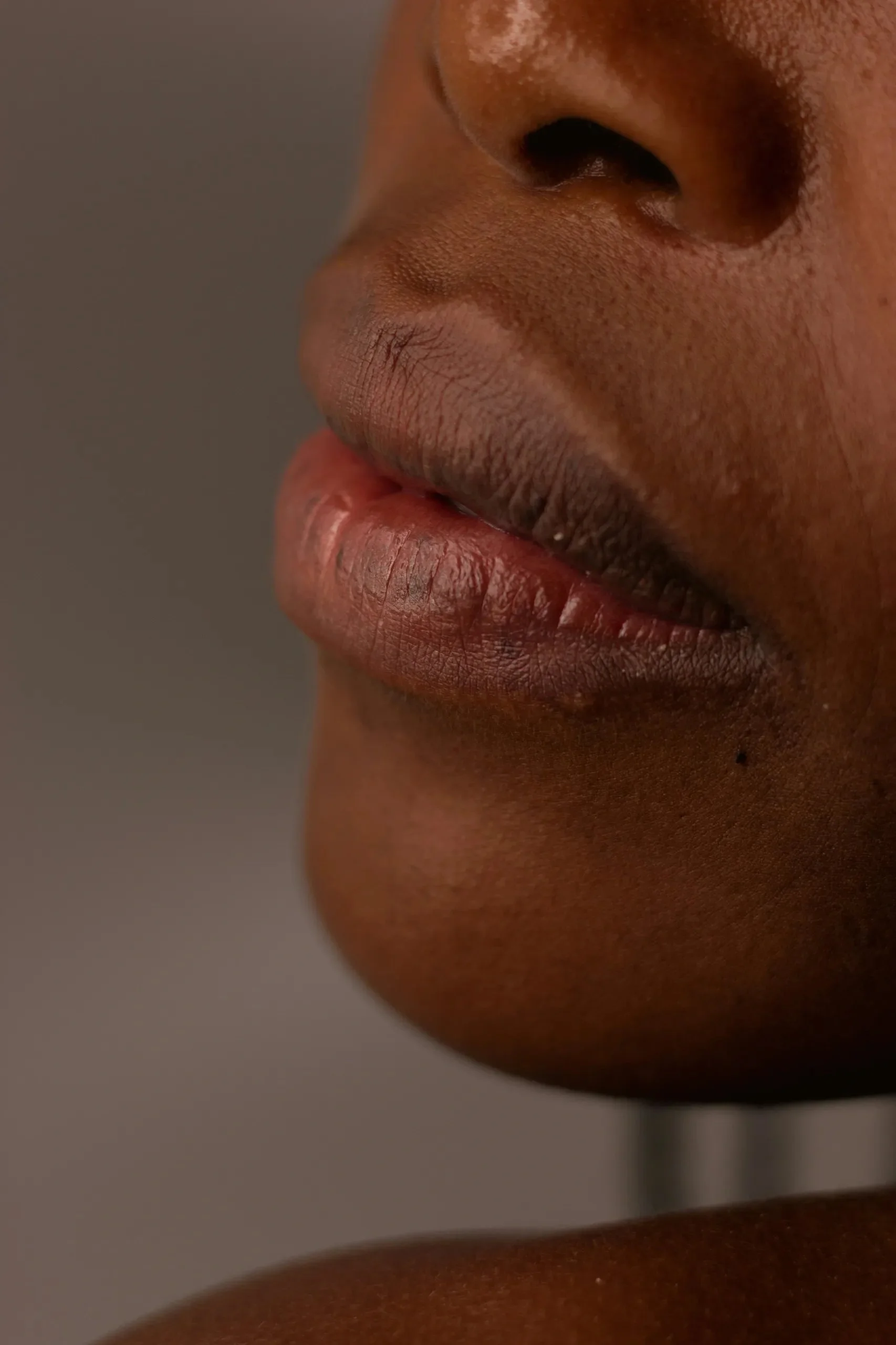 Close-up of a person's lips and nose, showing detailed skin texture and natural lip color.
